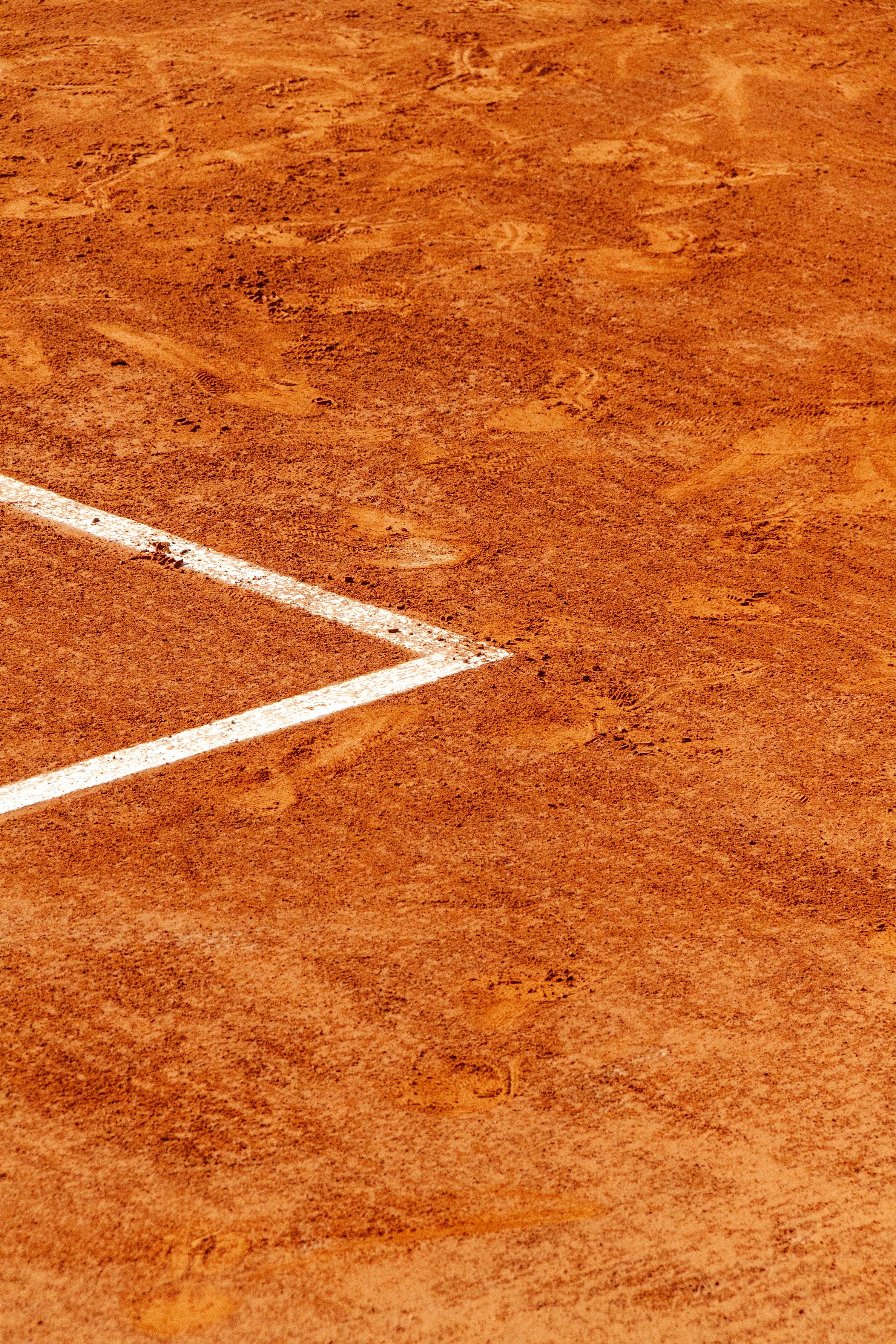 3000x4500 White lines mark a clay tennis court's corner. photo