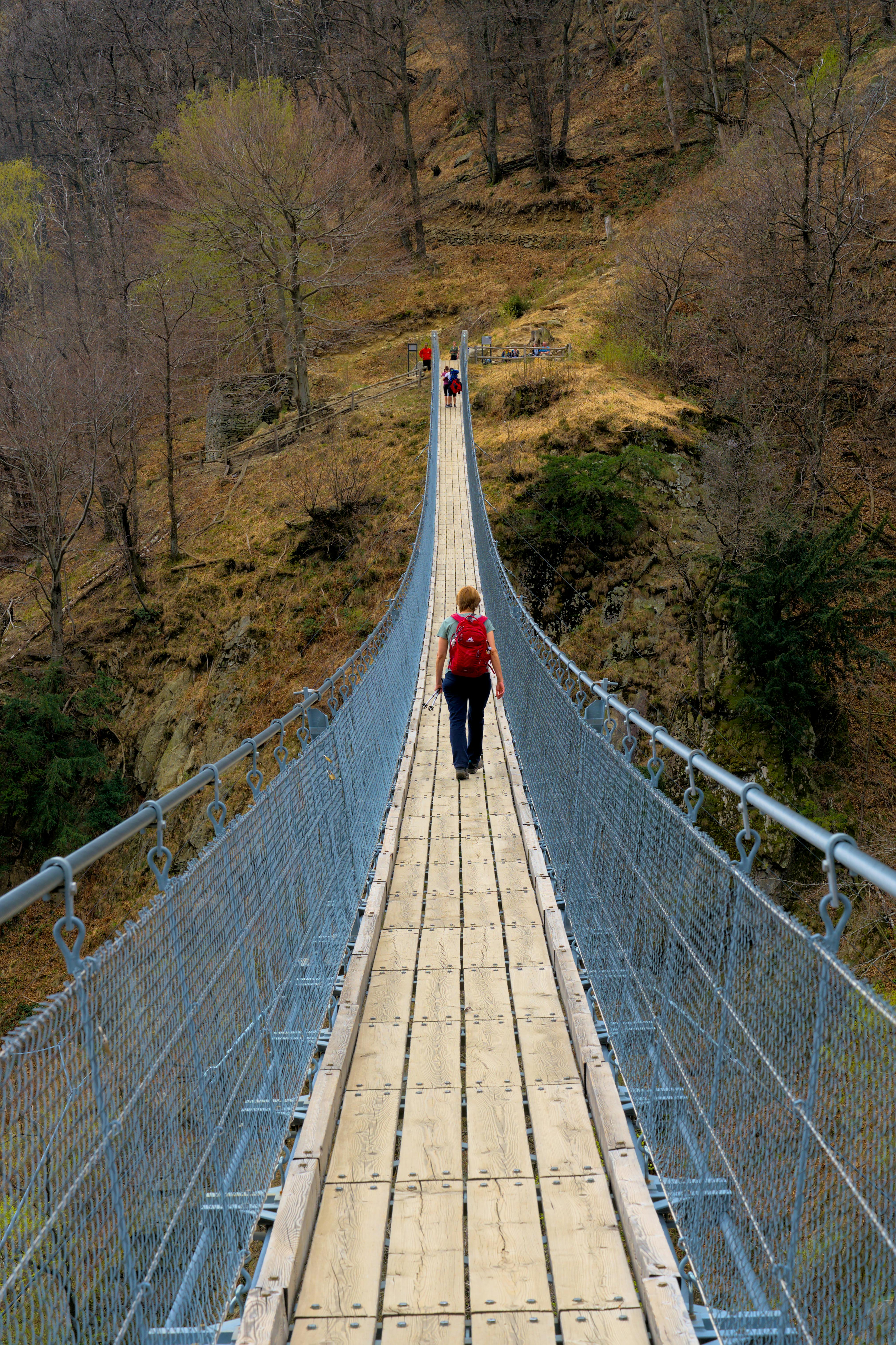 4040x6064 Hiker Crossing Suspension Bridge in Switzerland · Free