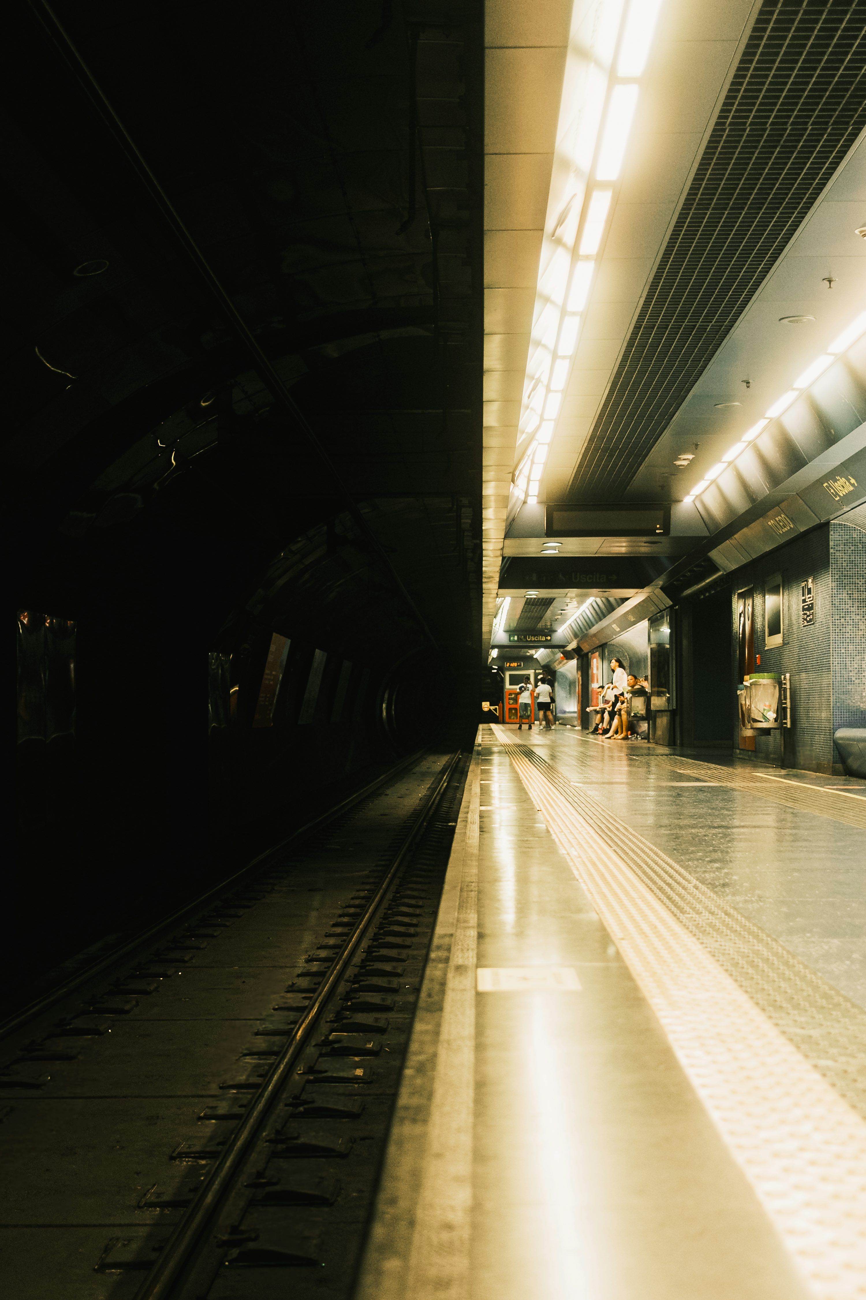 3000x4500 A dimly lit subway station platform with train tracks. photo