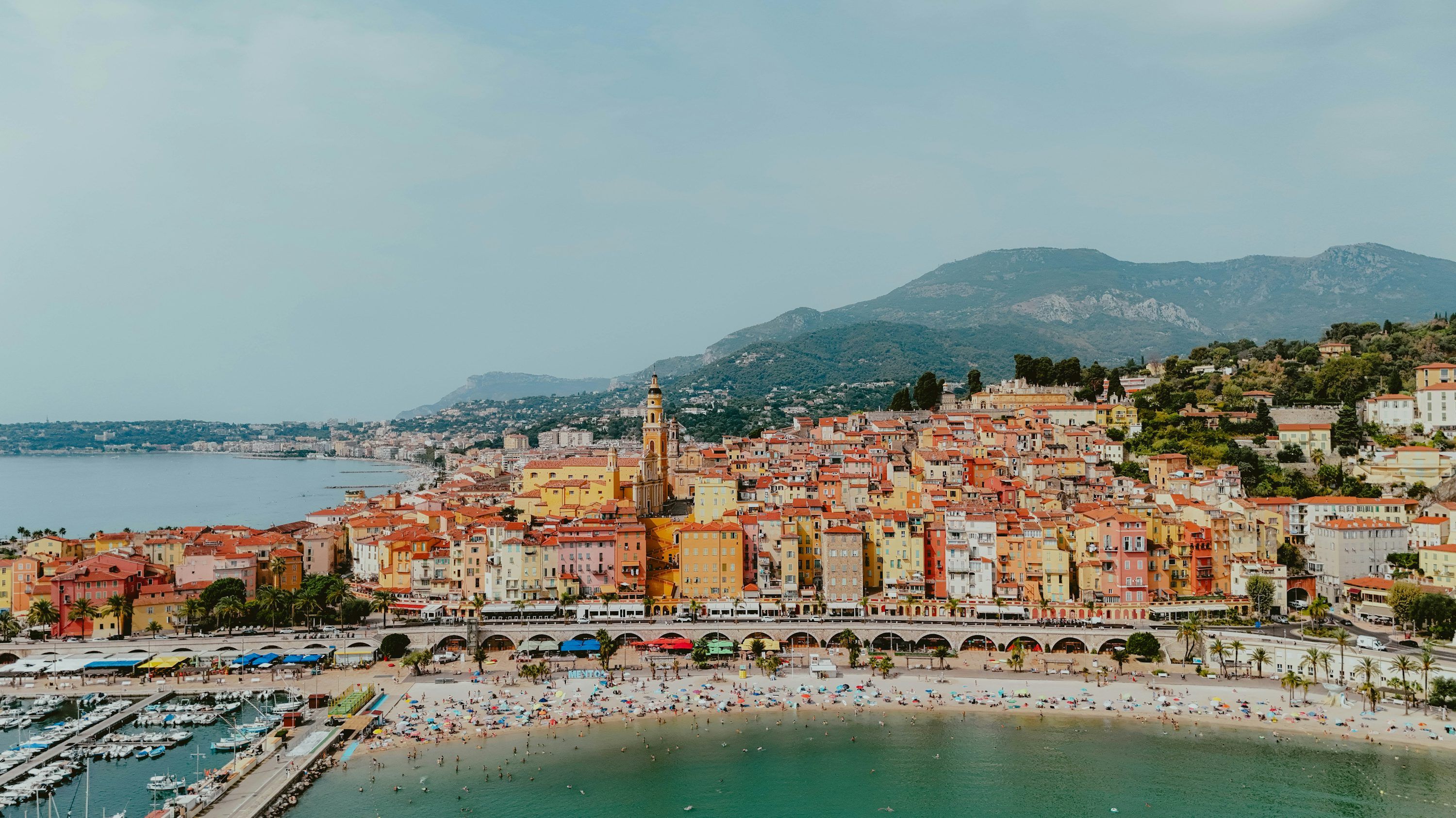 3000x1687 Colorful coastal town with a busy beach and harbor. photo