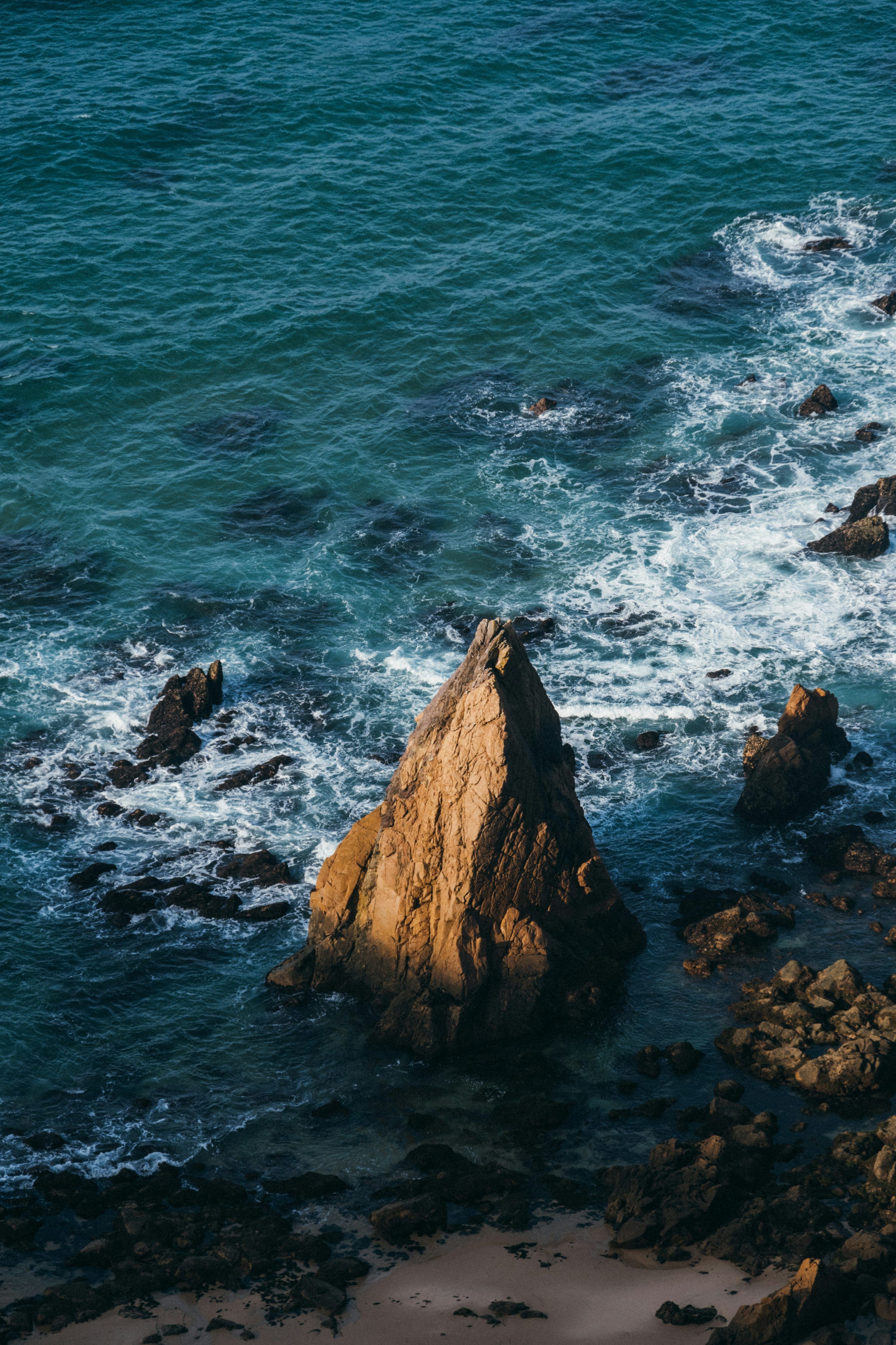 3000x4500 A couple of large rocks sitting on top of a beach photo