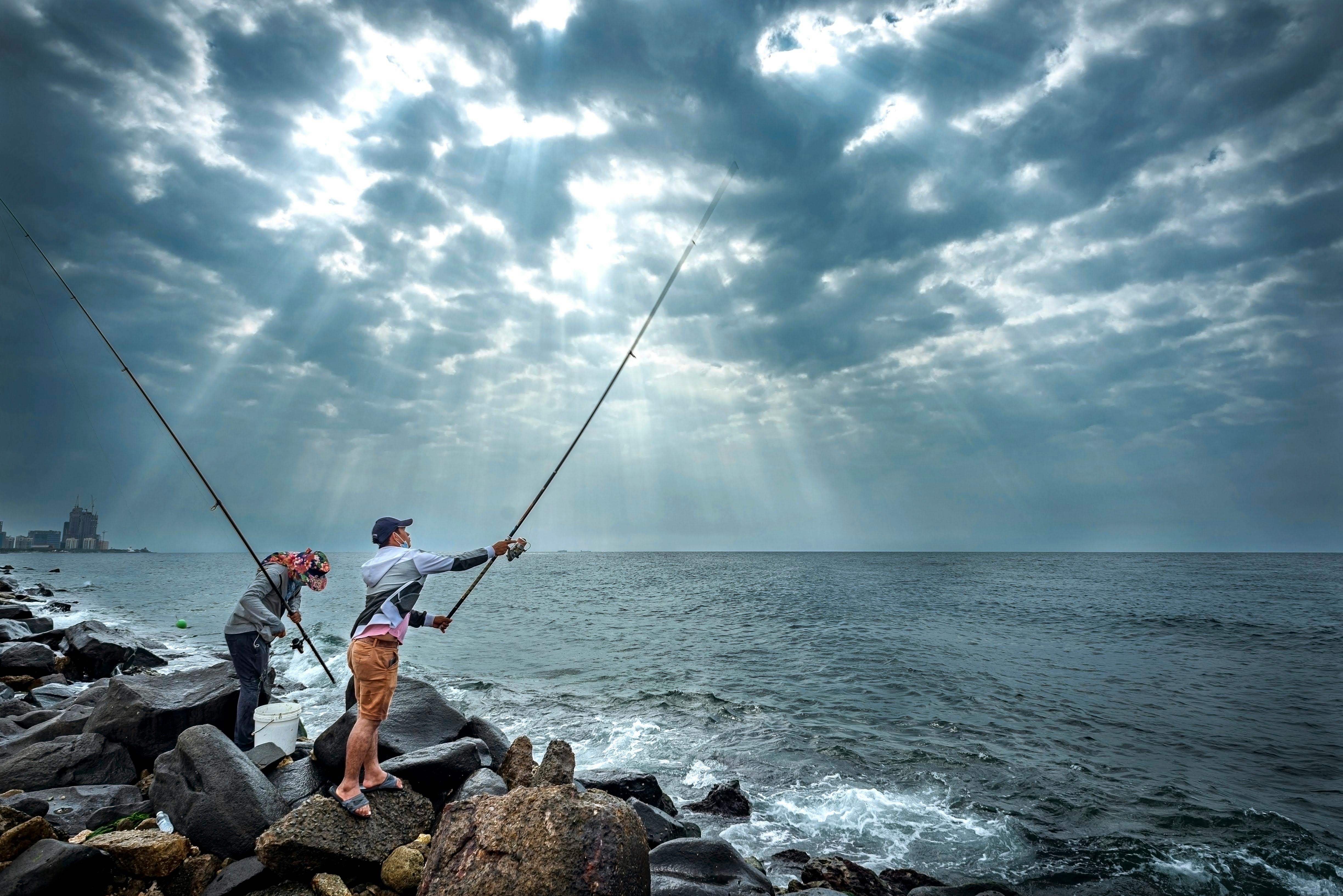 4895x3268 Men Fishing on Rocky Shore · Free