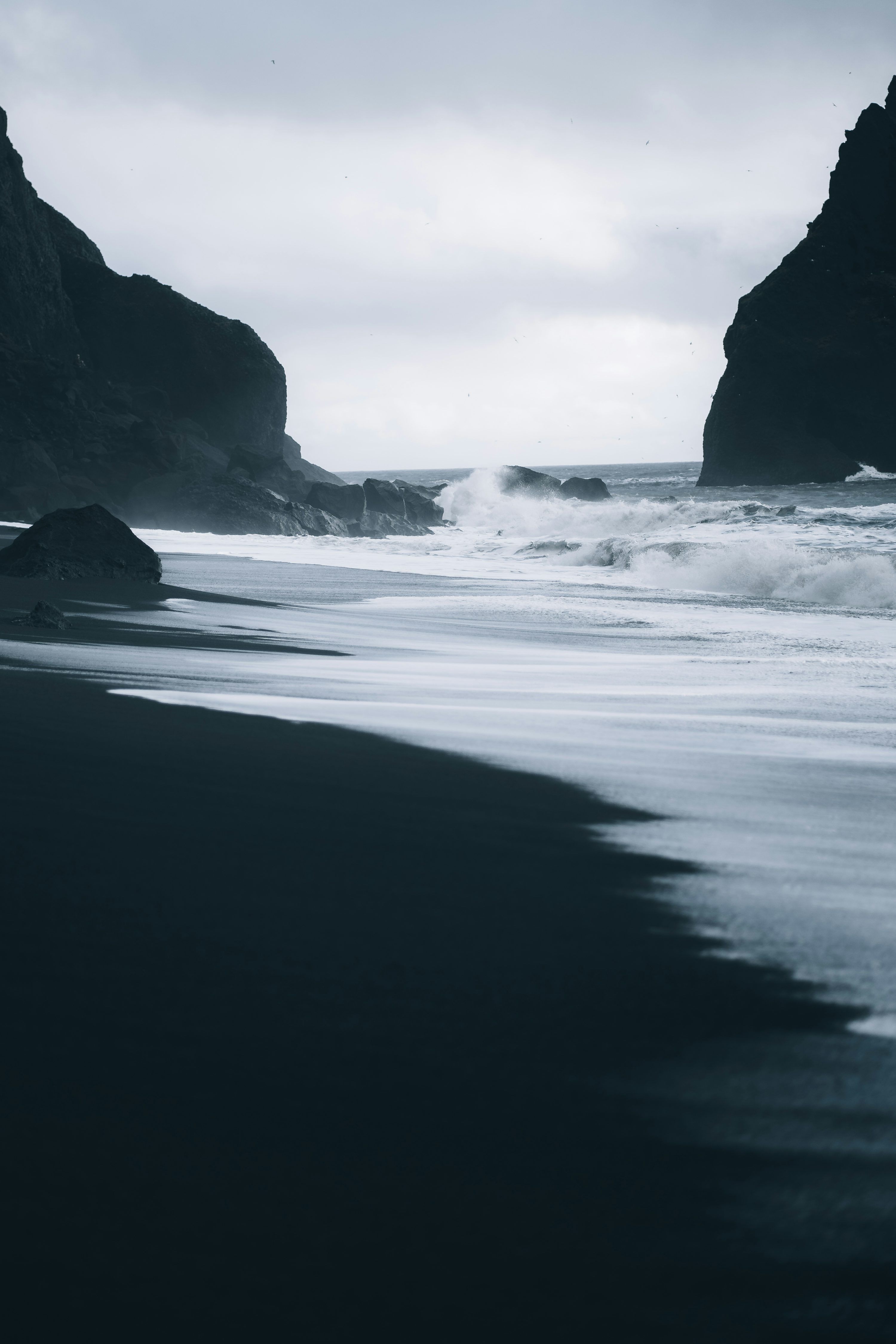 3000x4500 A black sand beach with waves coming in to shore photo