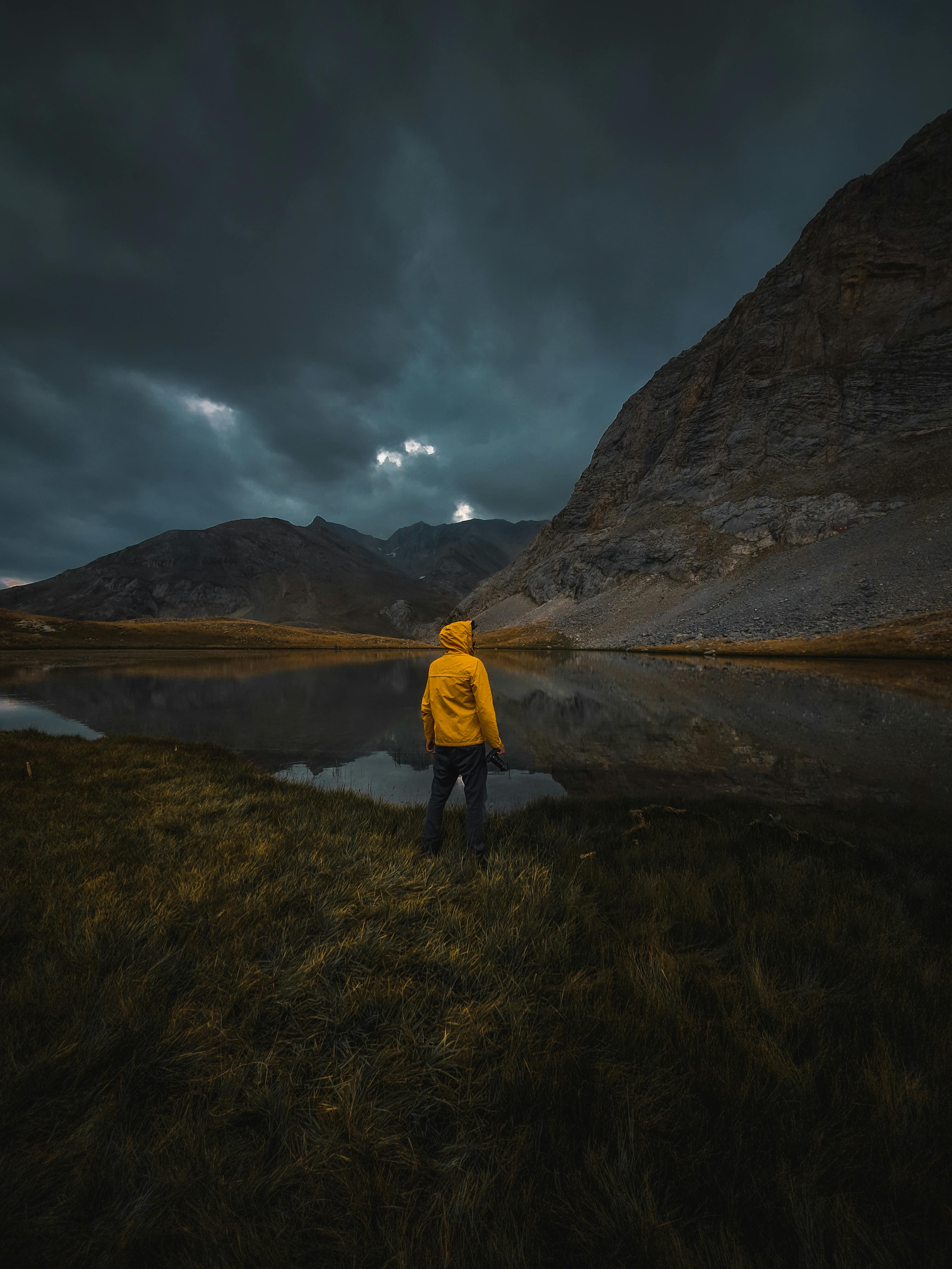3366x4487 Back View of a Person in Yellow Hoodie Jacket Standing in Front of Mountain Lake · Free