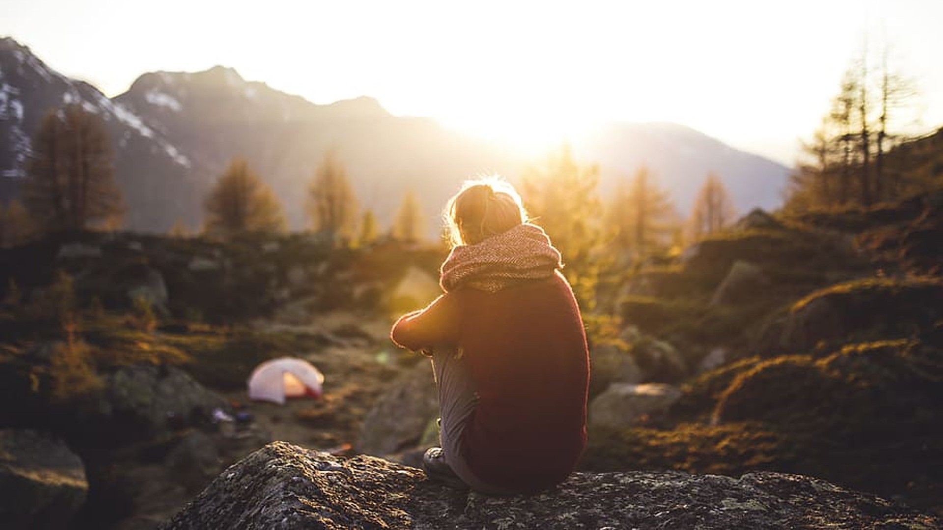 1920x1080 Girl Is Sitting Alone On Rock In Trees Mountains Sunrays Background HD Alone Wallpaper