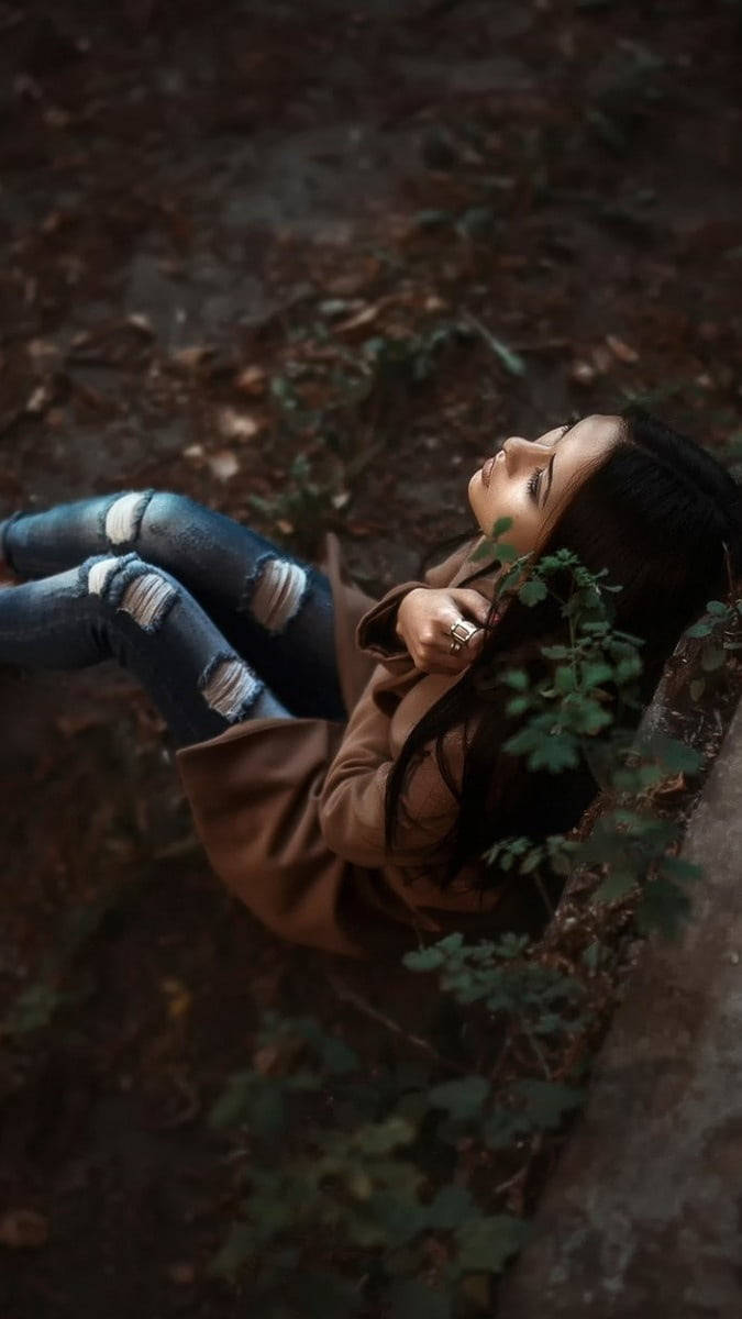 675x1200 Download Dramatic Girl Sitting In Forest Alone Wallpaper