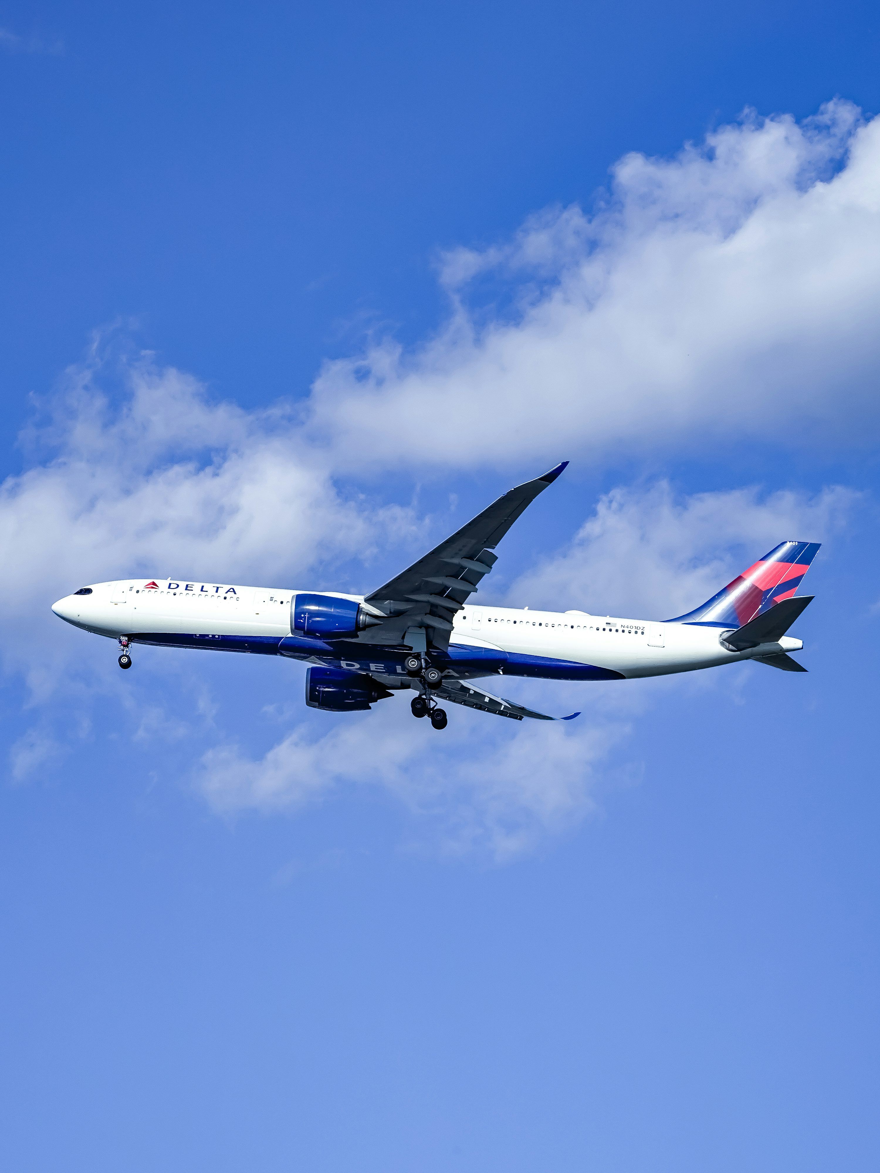 3000x4000 A delta airplane flying in a blue sky photo