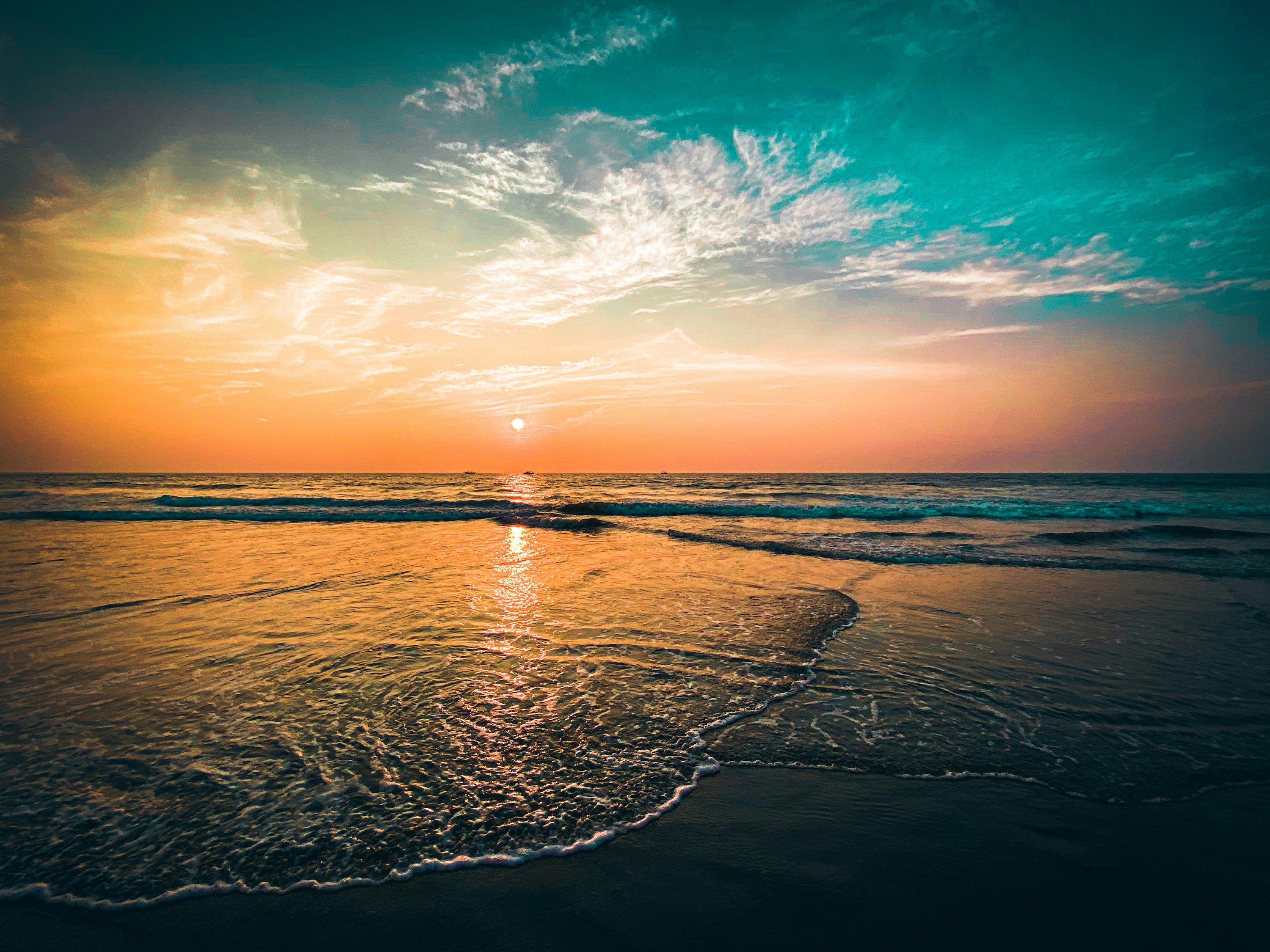 3000x2250 The sun is setting over the ocean on the beach photo