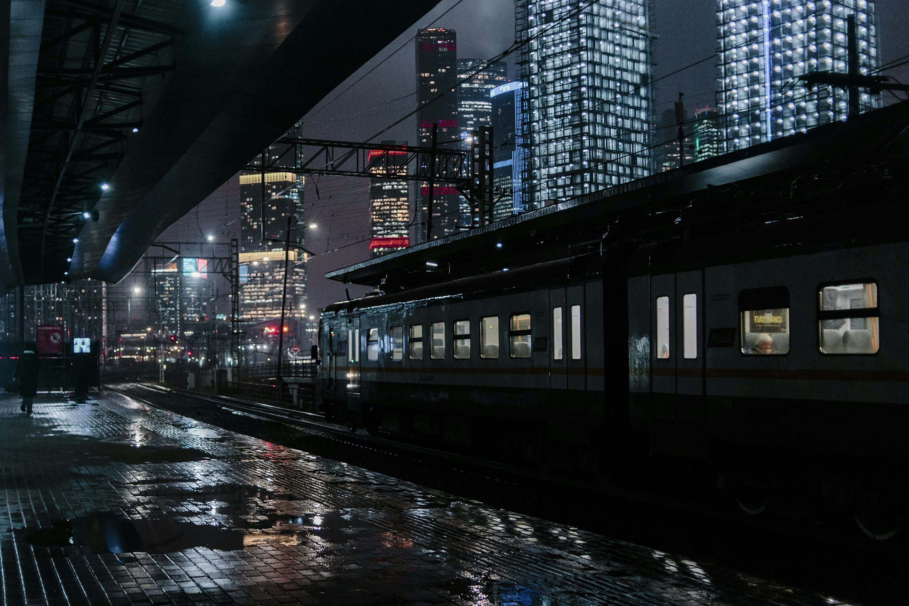 3000x2000 A train traveling through a city at night photo