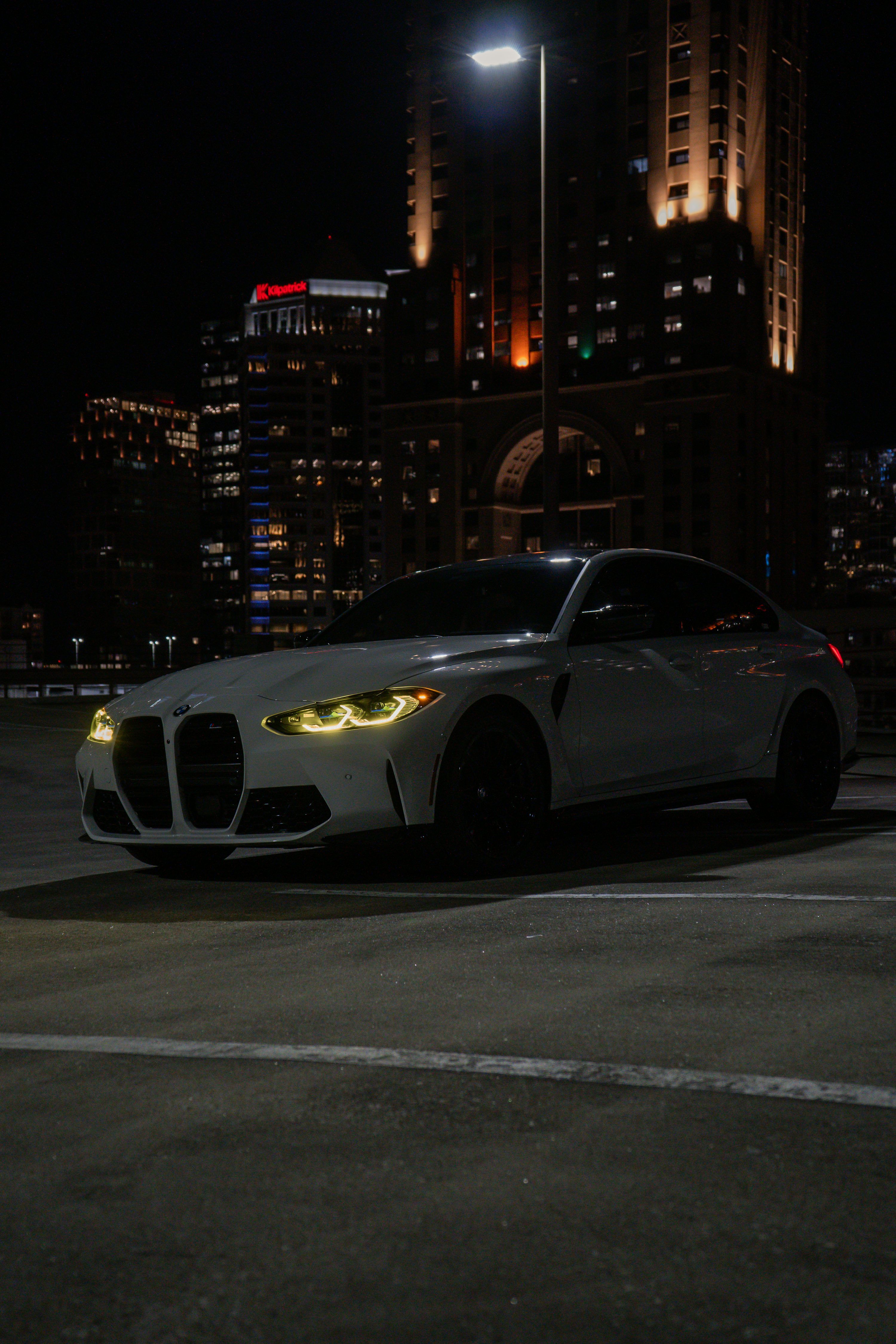 3000x4500 A white BMW m4 is parked at night. photo