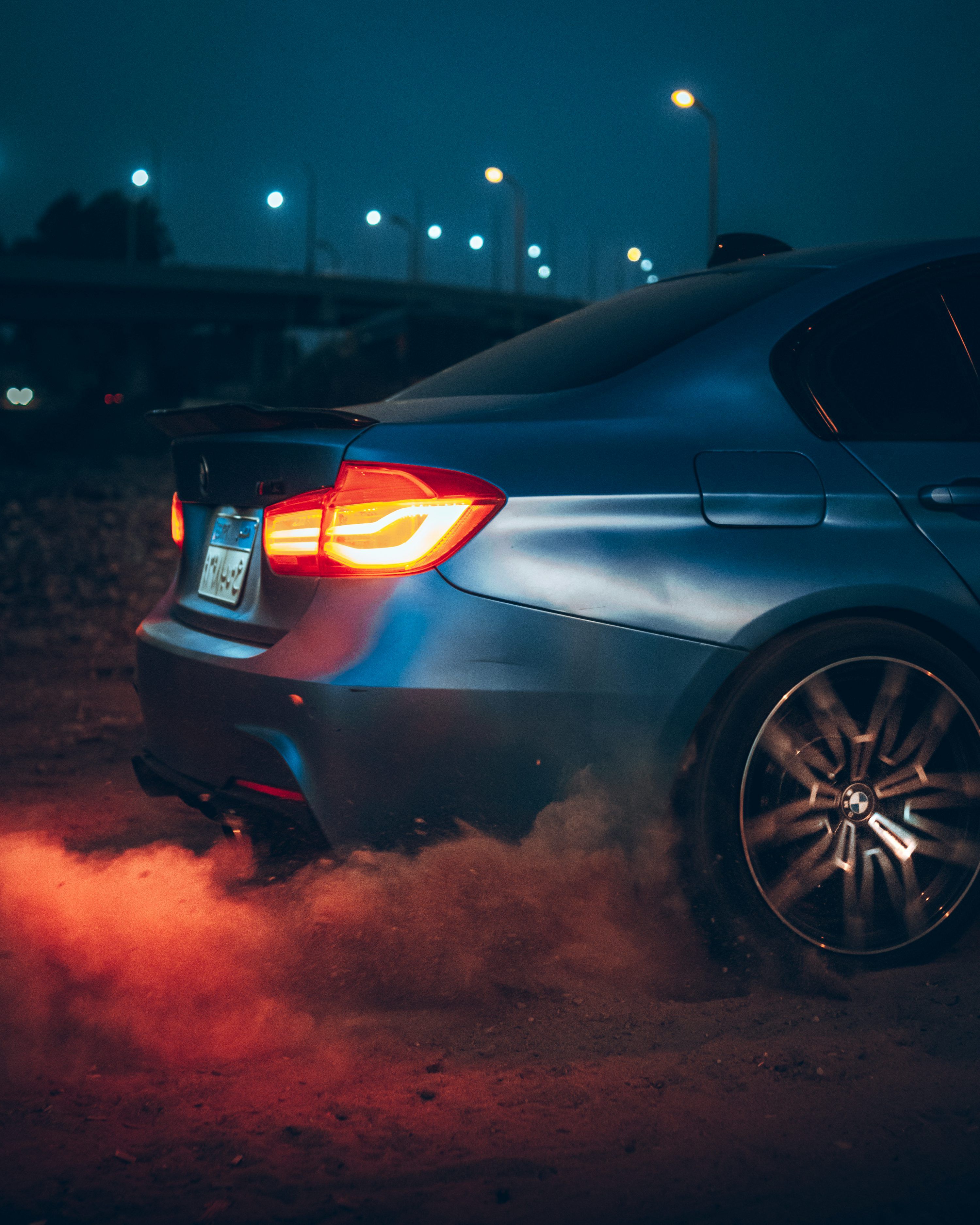 3000x3750 A blue car driving down a street at night photo