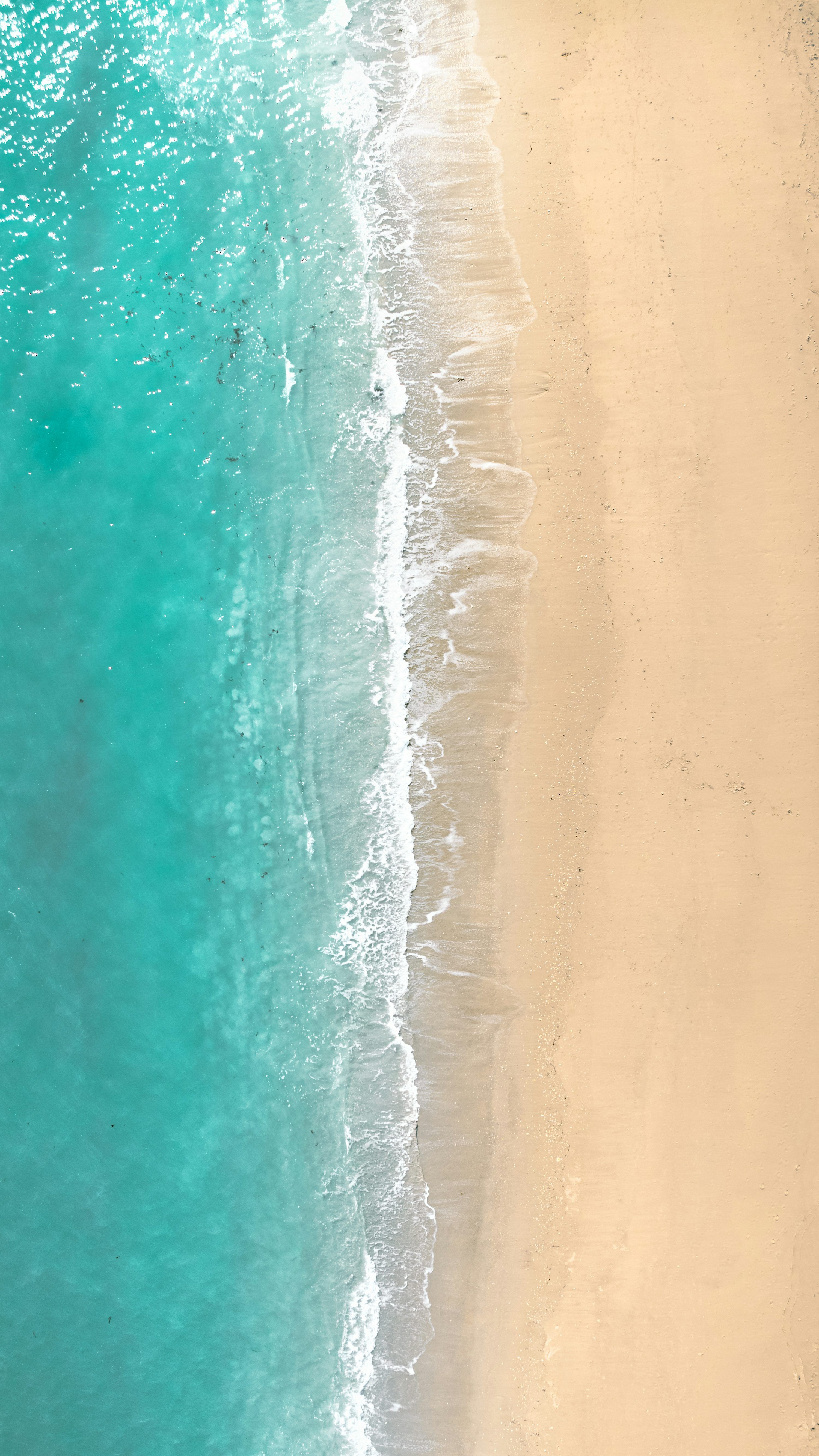 3000x5334 Turquoise ocean meets a sandy beach. photo