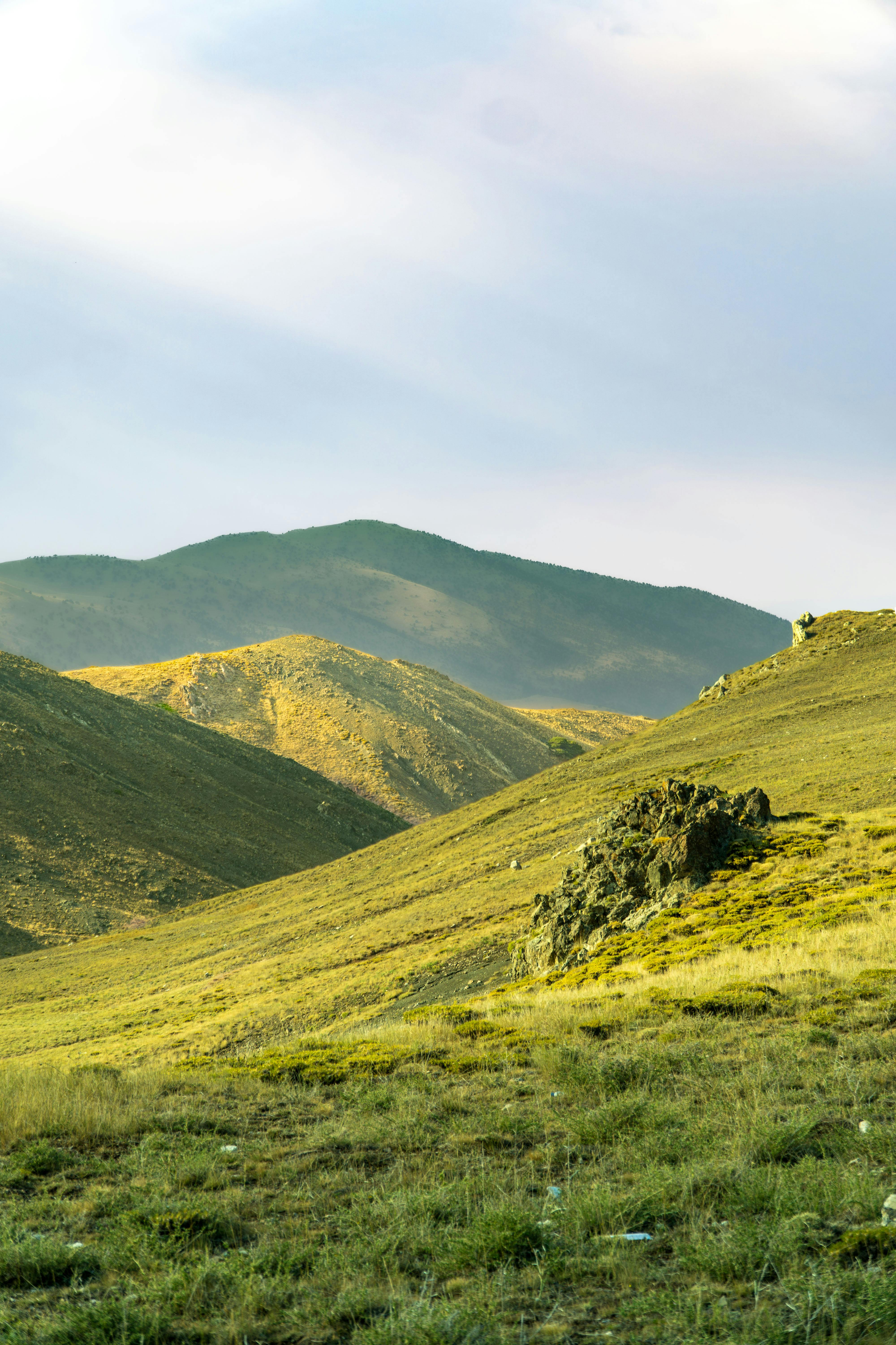 4000x6000 A grassy hill with mountains in the background · Free