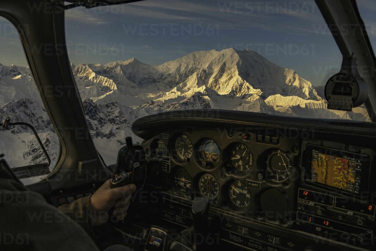 1232x822 Man flies a small airplane at sunset with alpenglow on mount Foraker
