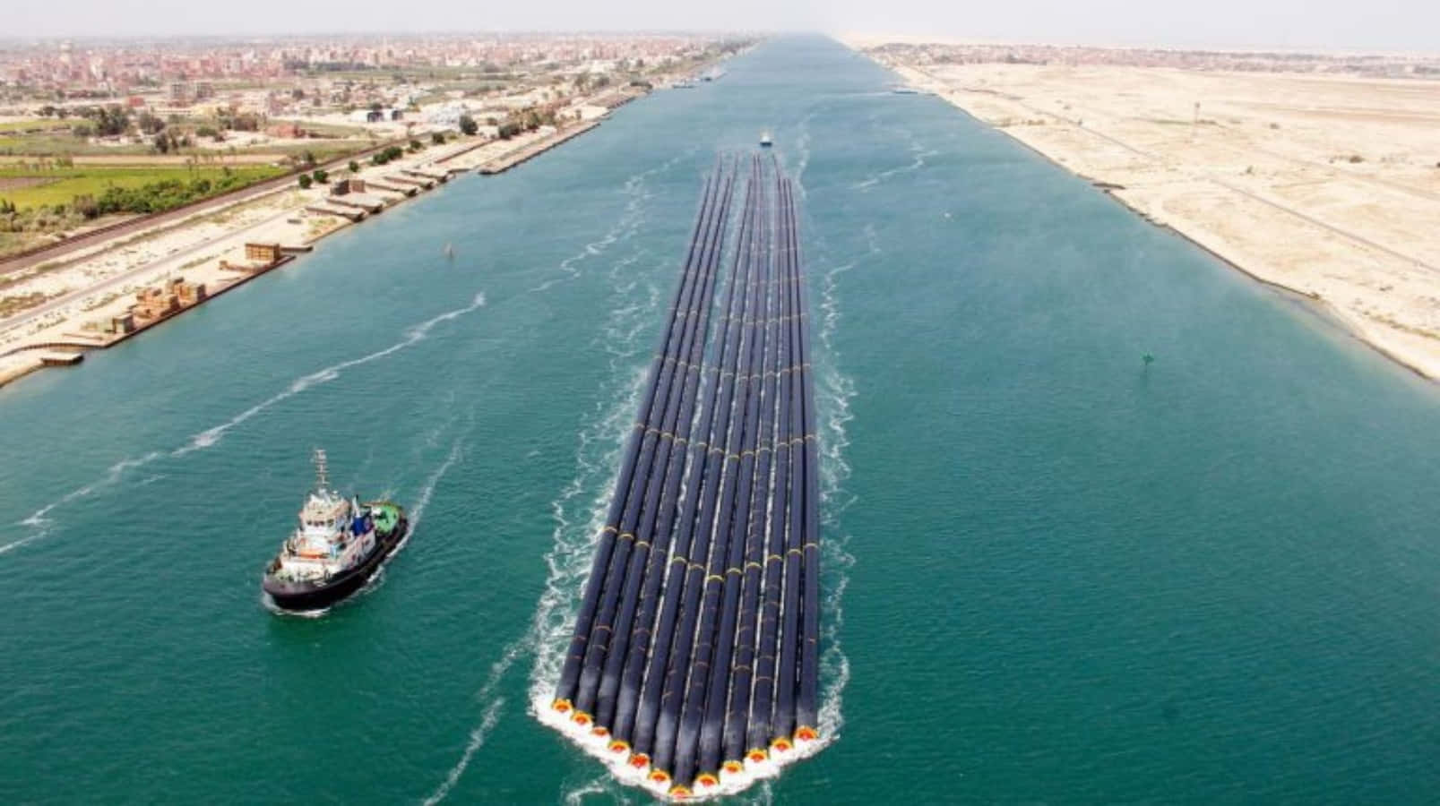 1607x900 Download A Boat Is Traveling Down A River With A Large Pipe