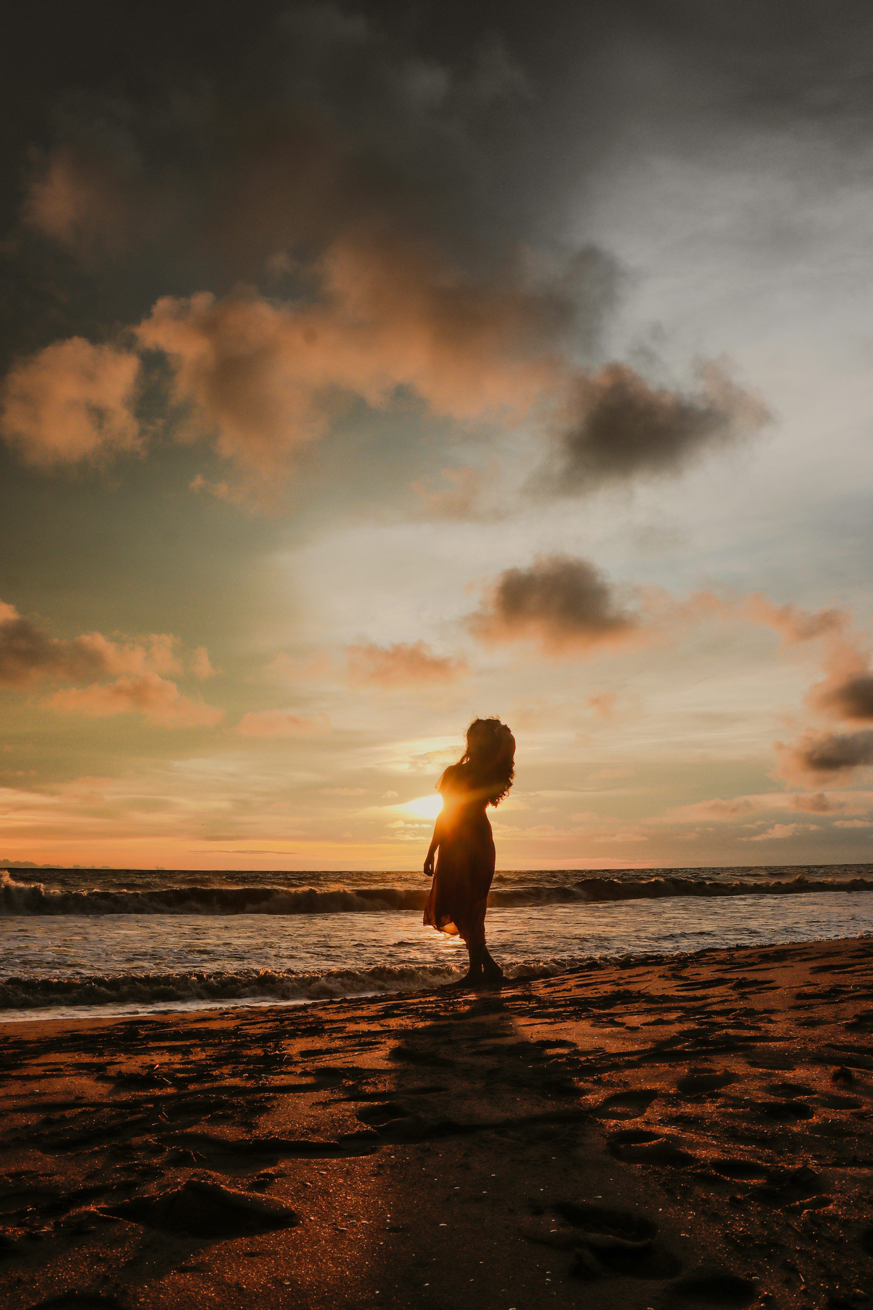 3000x4500 Woman enjoys a sunset at the beach. photo
