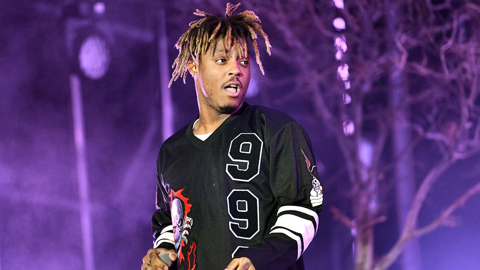 1920x1080 Juice Wrld Is Standing In Purple Lights Tree Background Wearing Black Dress HD Juice Wrld Wallpaper