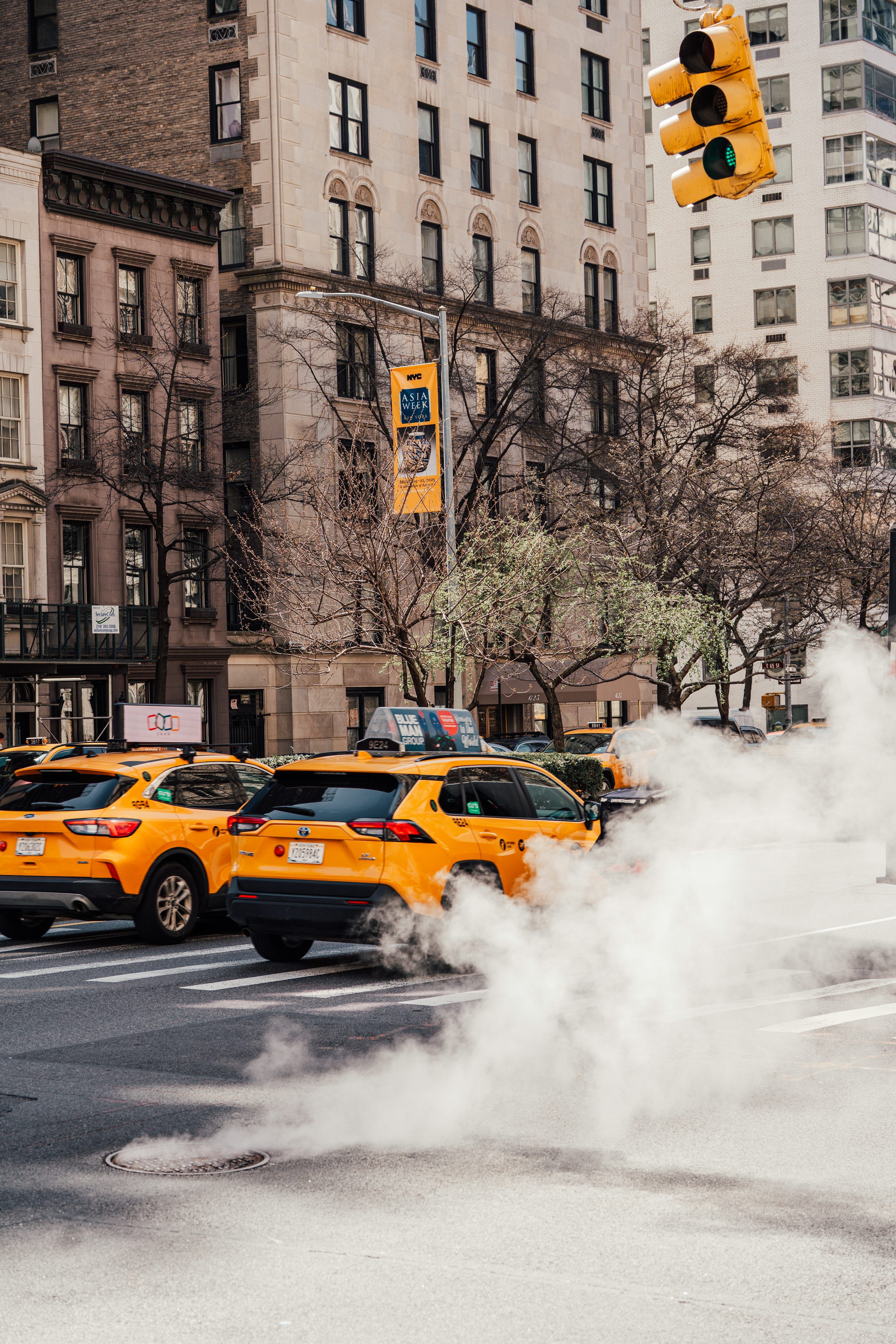 3000x4500 Yellow taxis on a city street with steam rising. photo