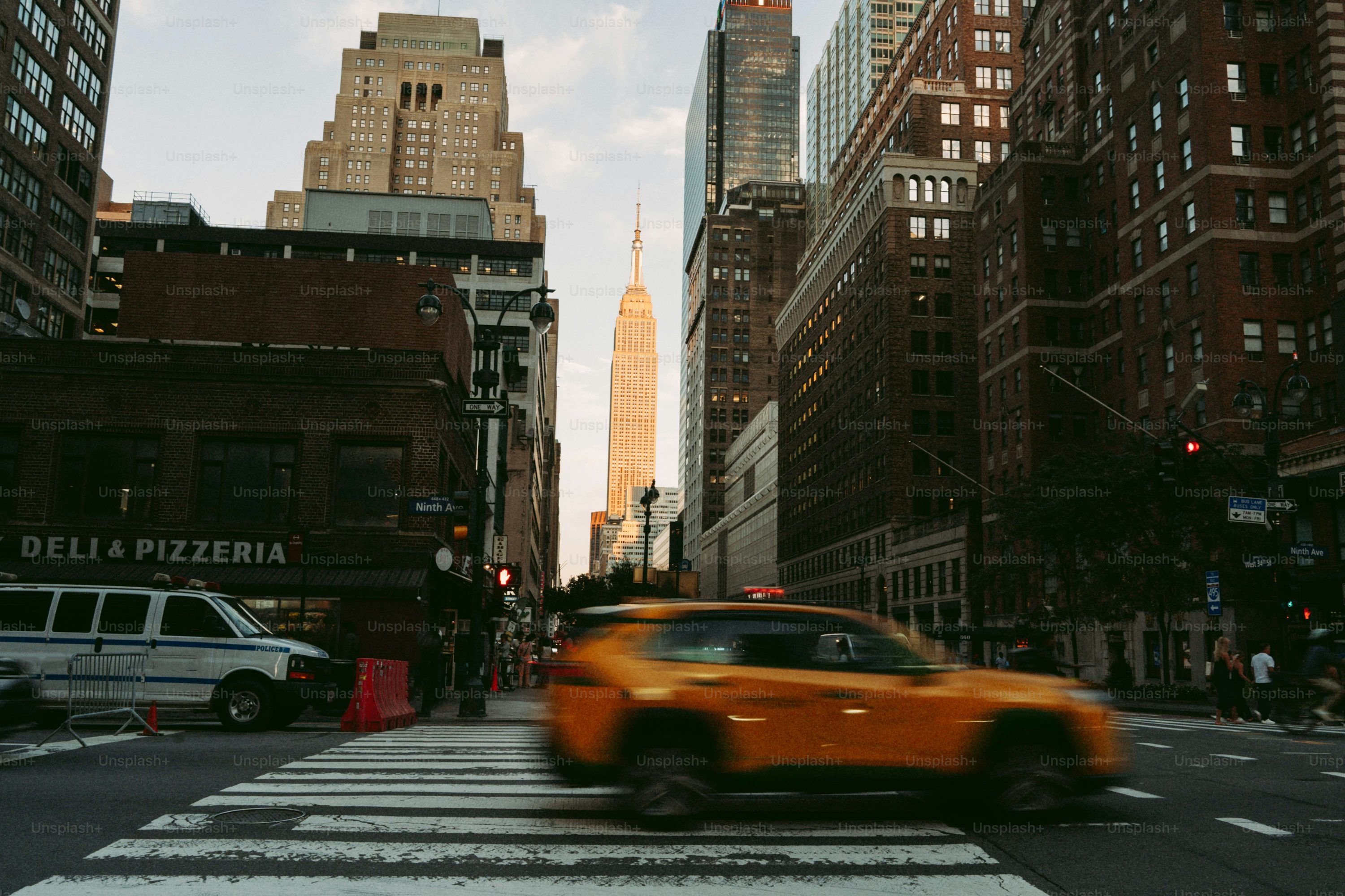 3000x2000 Yellow taxi crosses street in front of empire state building. photo