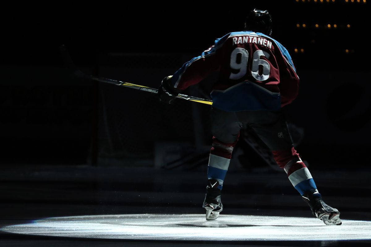1200x800 Download Back Shot Of Mikko Rantanen Raising Hockey Stick Under The Spotlight Wallpaper