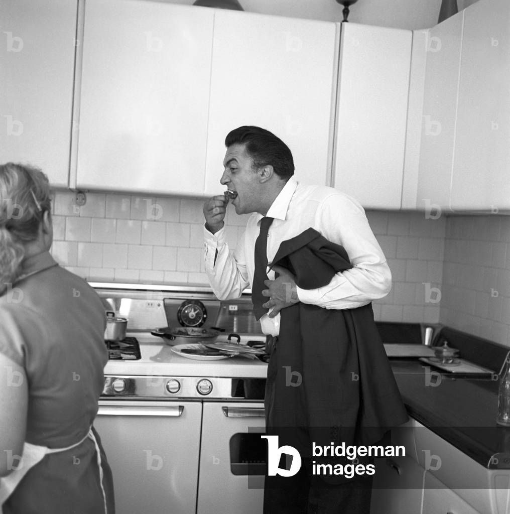 1016x1024 Image of Italian director Federico Fellini photographed while eating in his kitchen