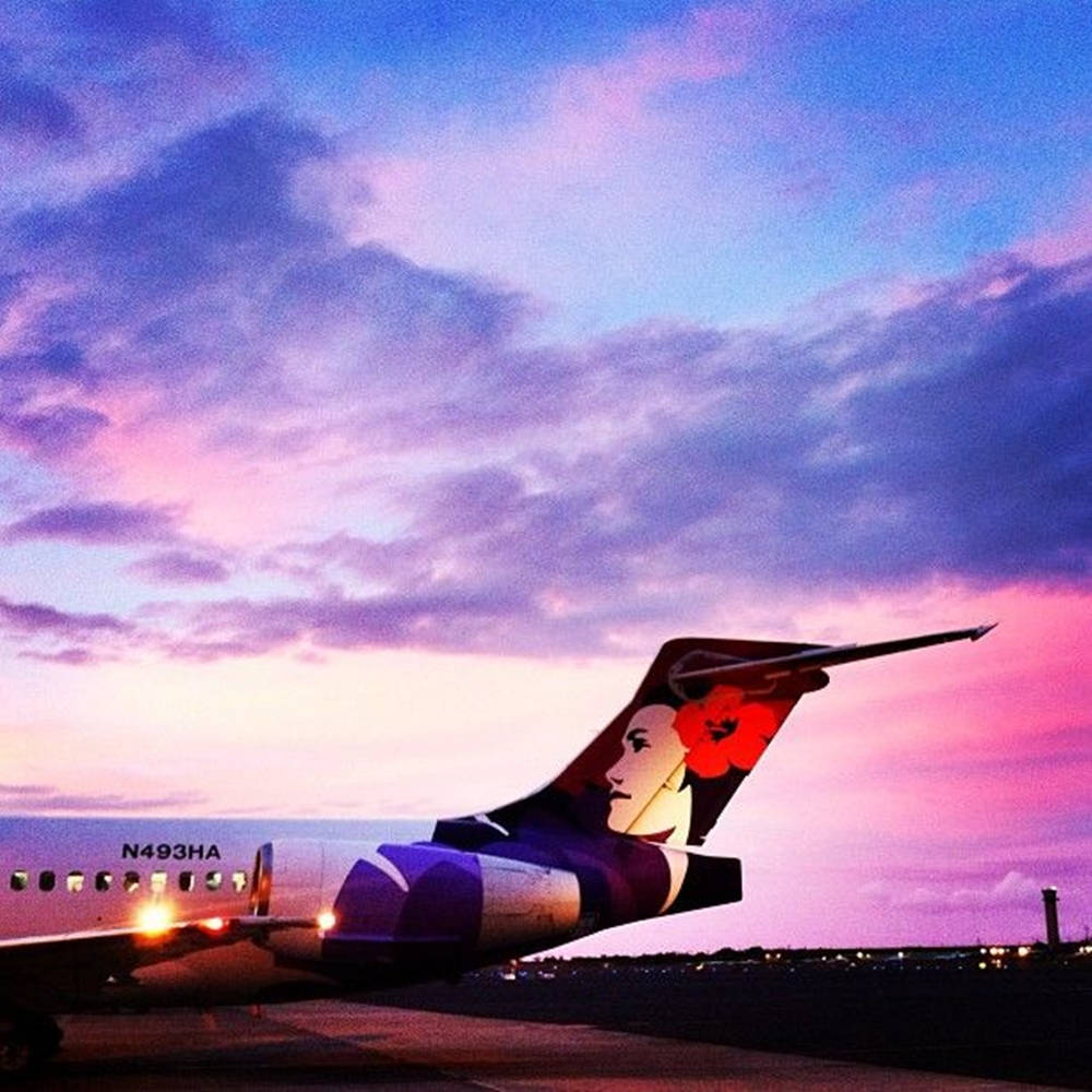 1000x1000 Download Hawaiian Airlines Jet Gliding Against the Purple Twilight Wallpaper