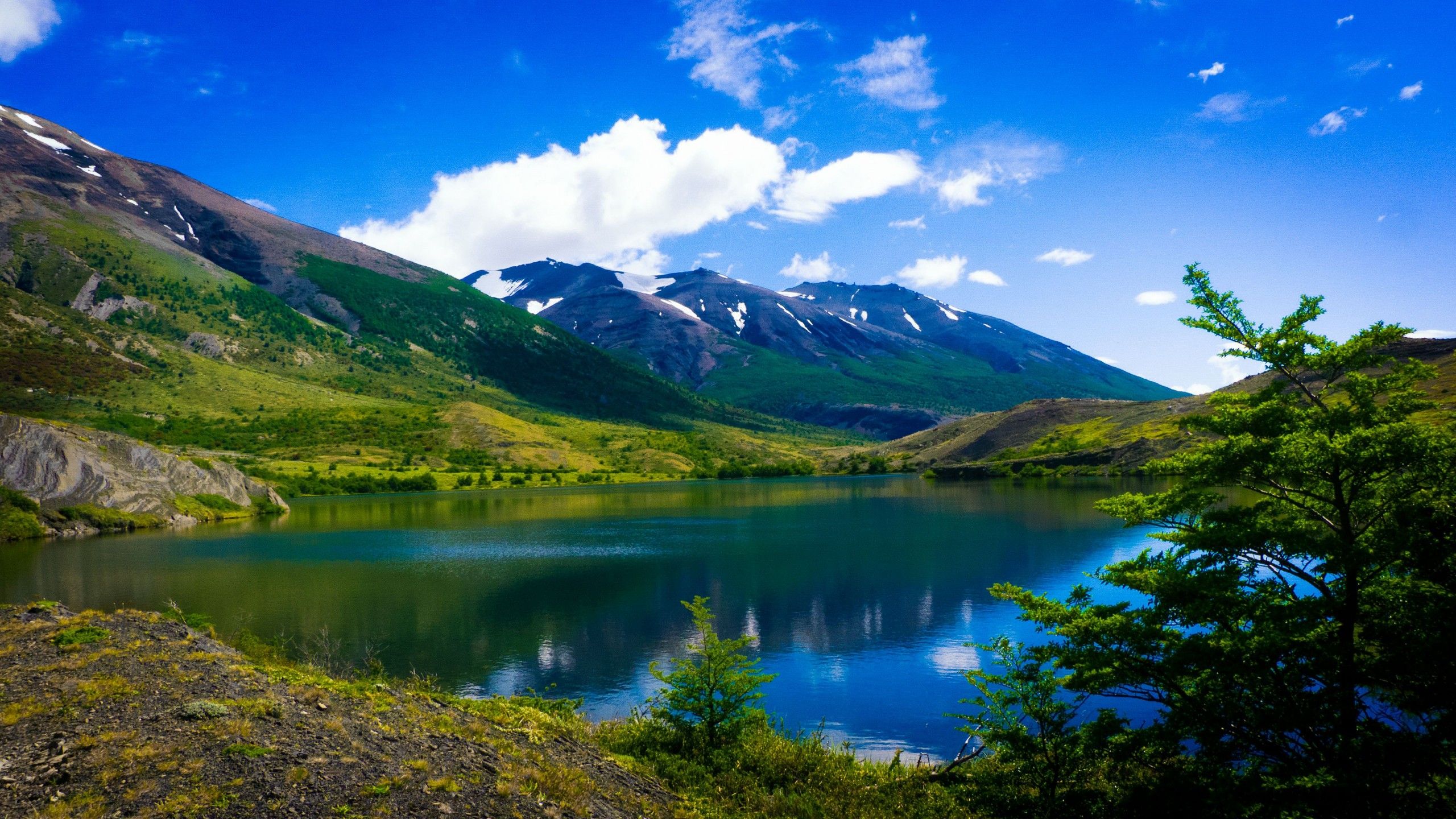 2560x1440 Landscape View Of Beautiful Mountains Lake Reflection Grass Field 4K HD Nature Wallpaper