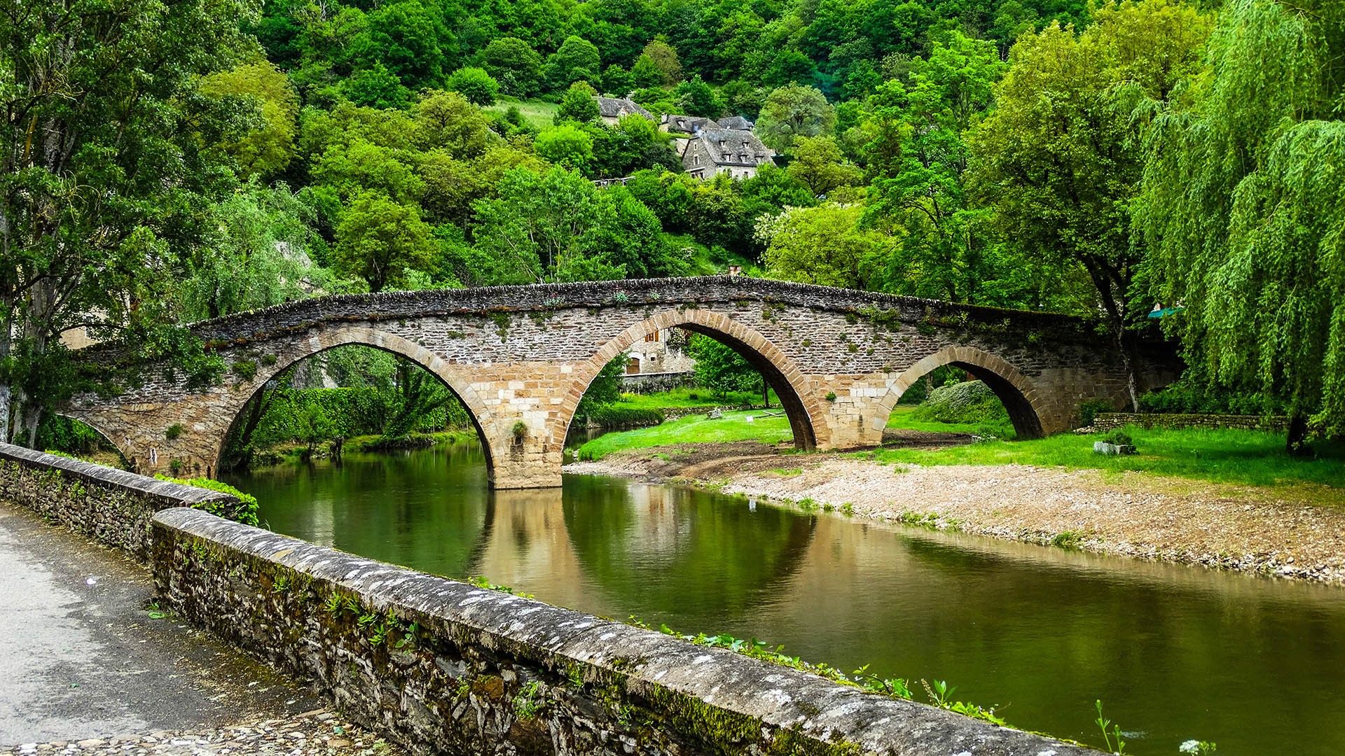 1920x1080 Belcastel medieval stone bridge across Aveyron river with forest, Aveyron, France. Windows Spotlight Image