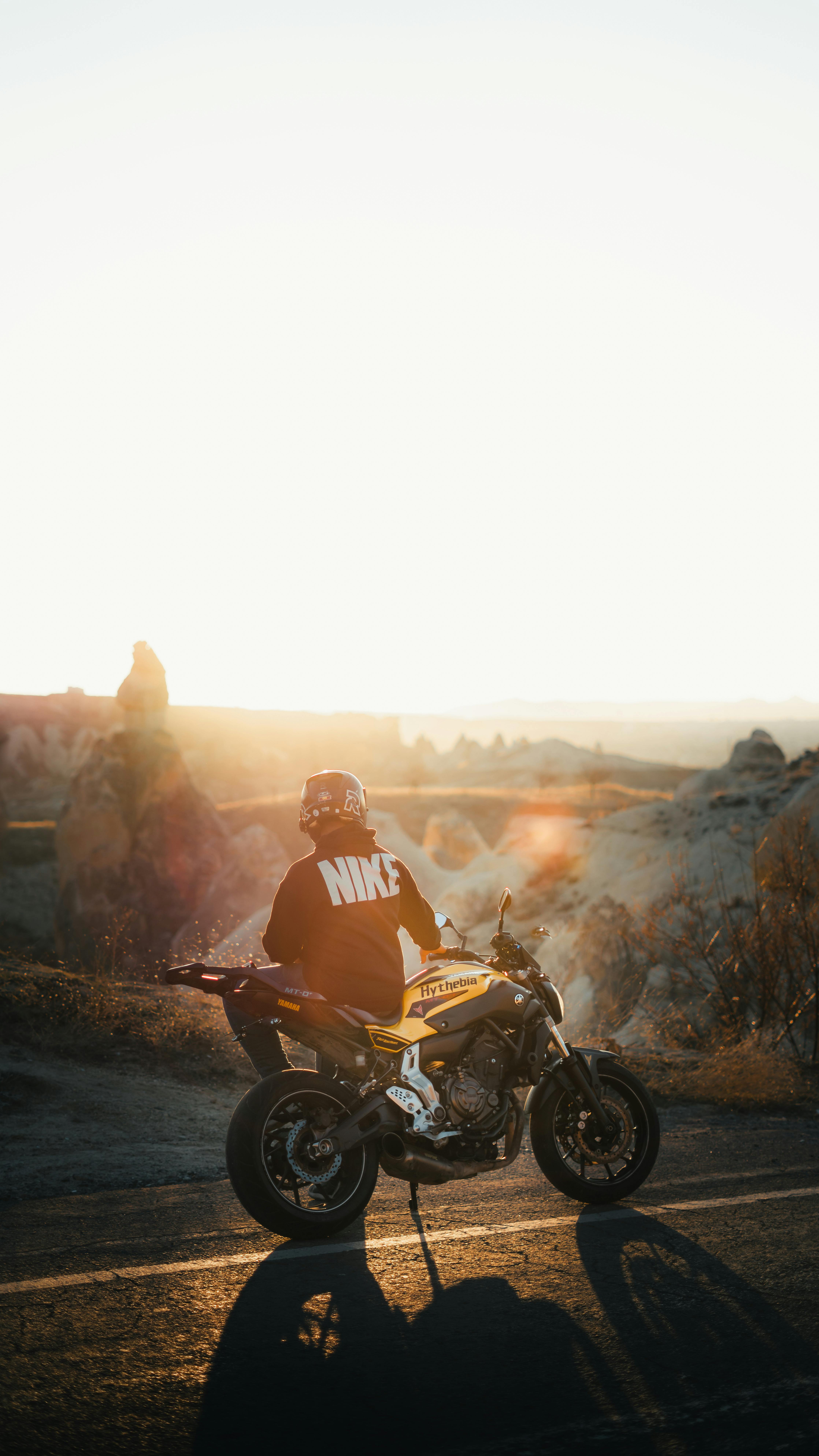 4472x7952 Man Sitting on Motorbike in Mountains Landscape on Sunset · Free