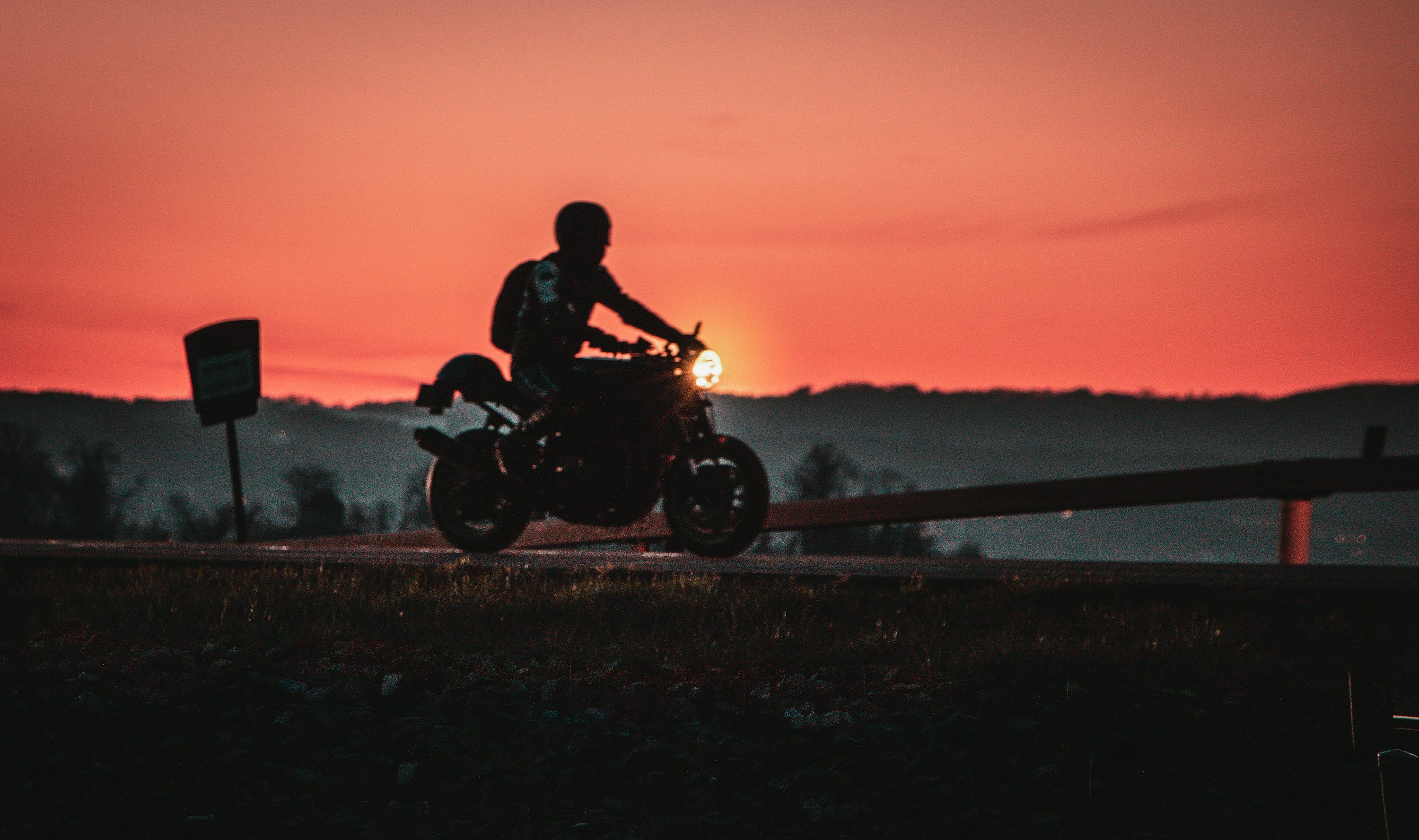 3000x1776 A person riding a motorcycle at sunset photo