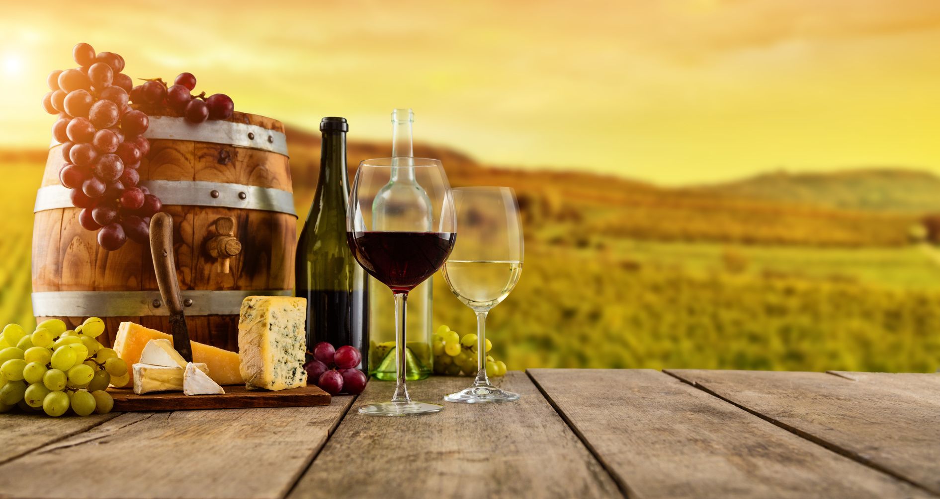 1891x1005 Red and white wine served on wooden planks, vineyard on background. Roger Doumanian, Attorney at Law, APC