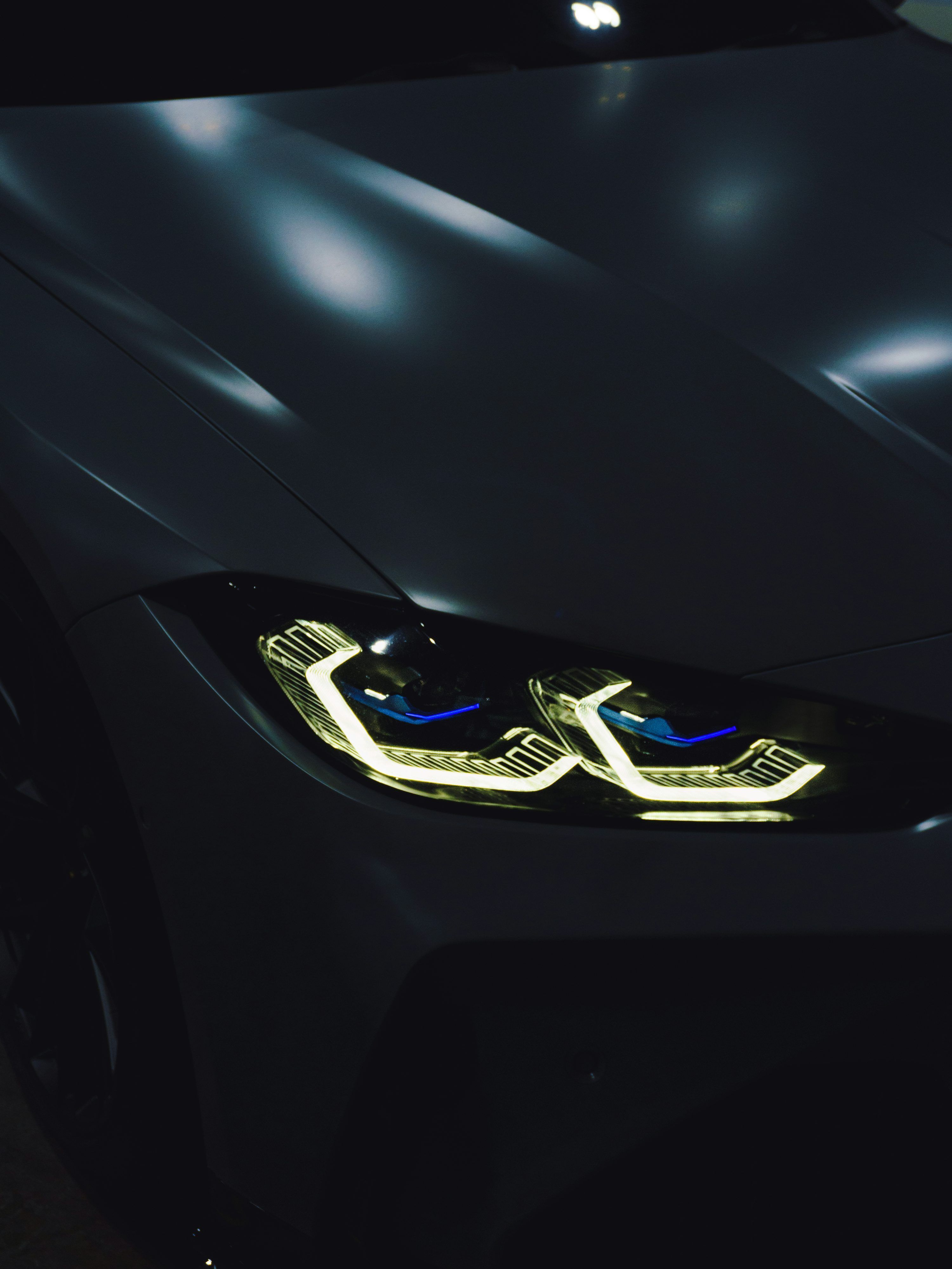 3000x3996 A close up of a car's headlights in the dark photo