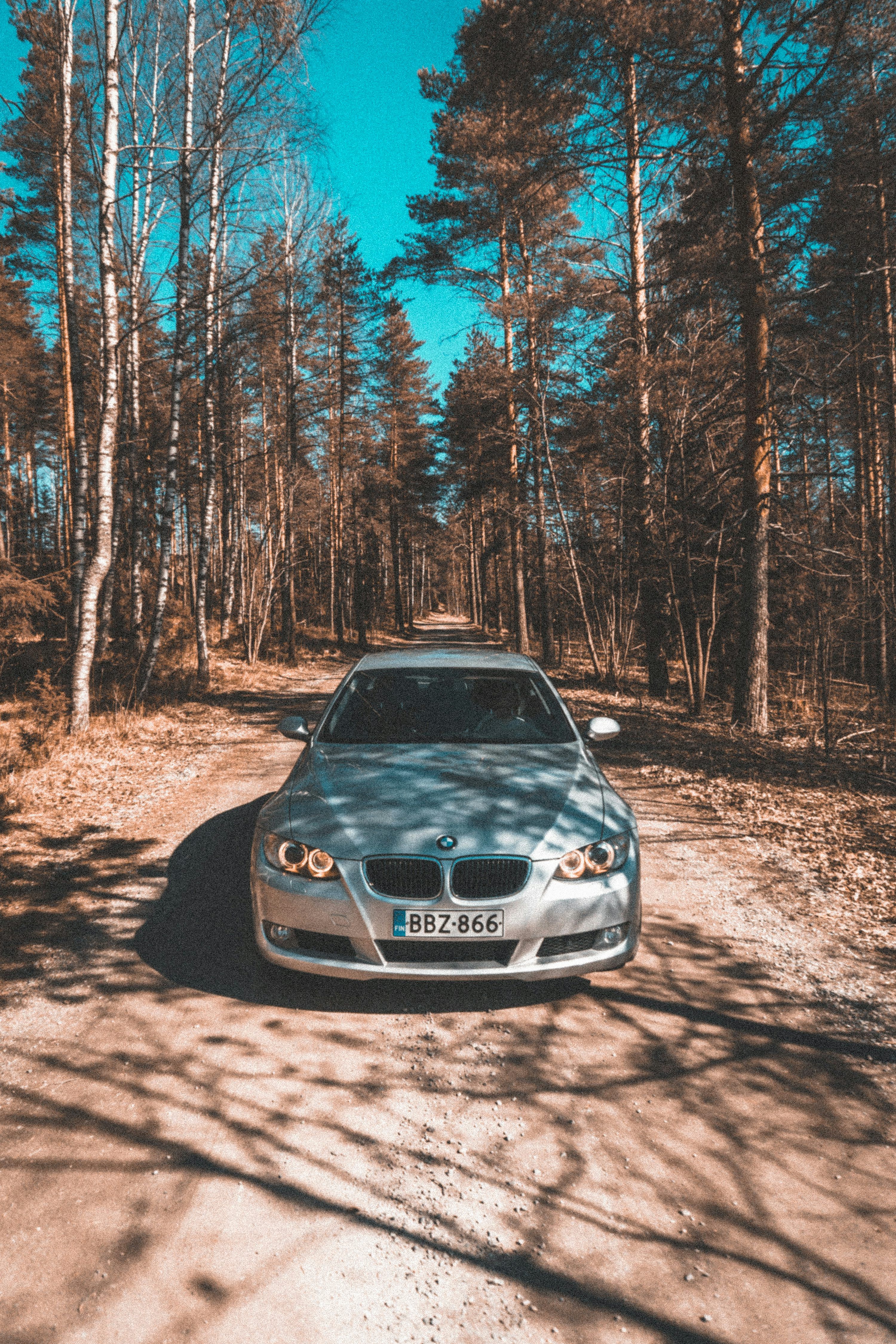 3000x4500 Black bmw m 3 parked on brown dirt road in between trees during daytime photo