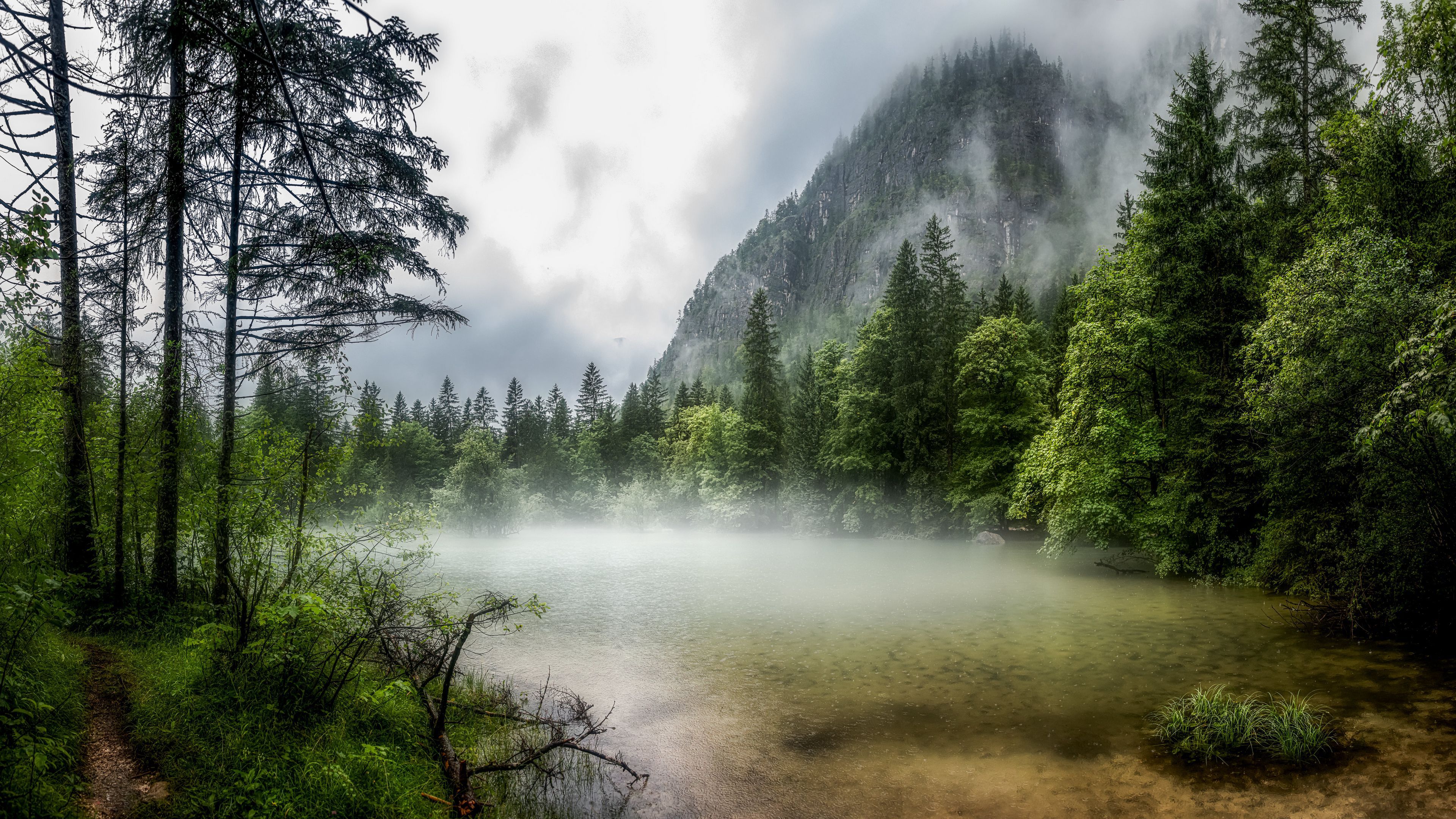 3840x2160 Beautiful Lake Surrounded By Green Trees Forest In Foggy Mountains Background 4K HD Nature Wallpaper