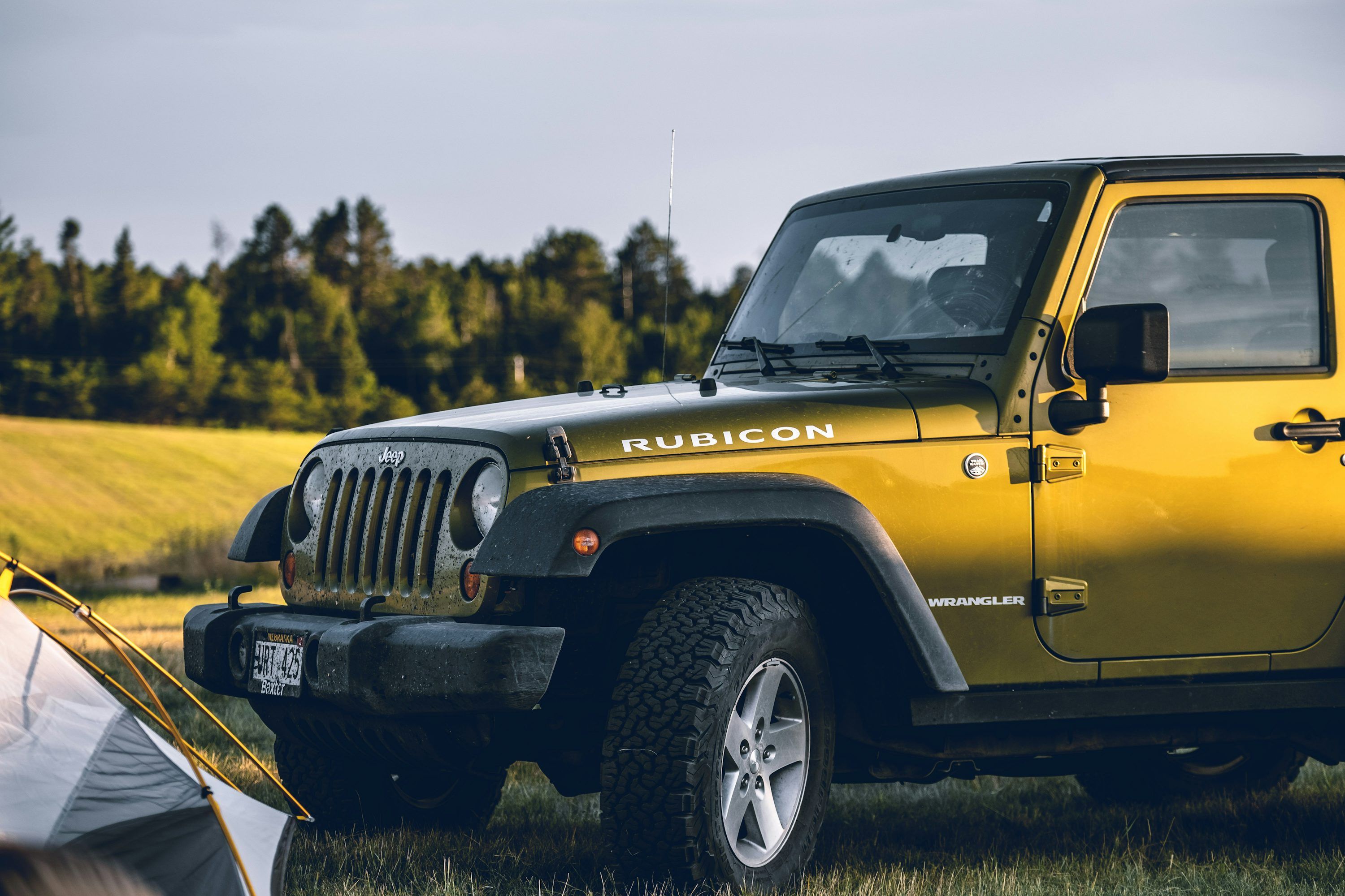 3000x2000 Yellow Jeep Wrangler Rubicon on grass field near tent during daytime photo