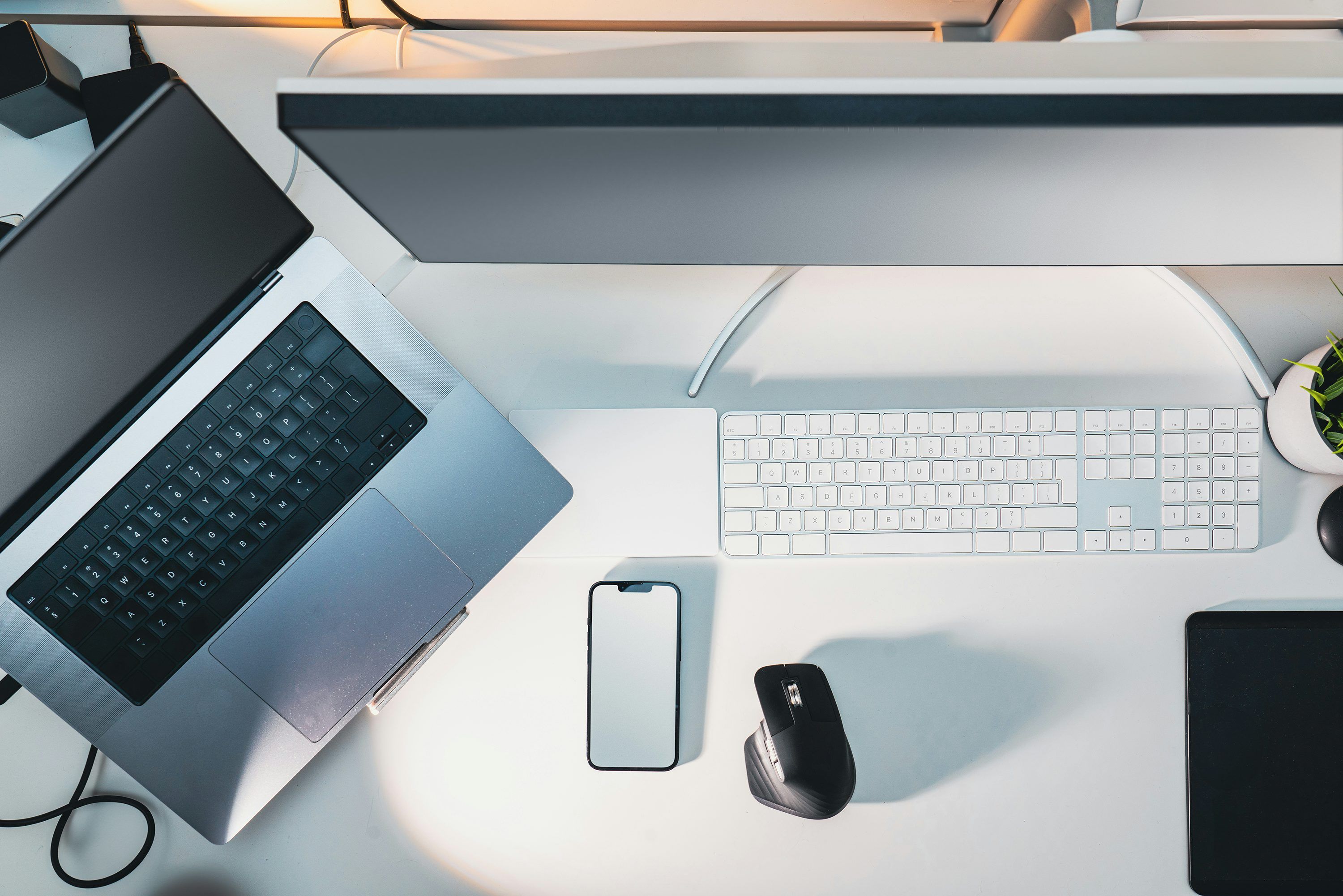3000x2001 A desk with a laptop, keyboard, mouse and a cell phone photo