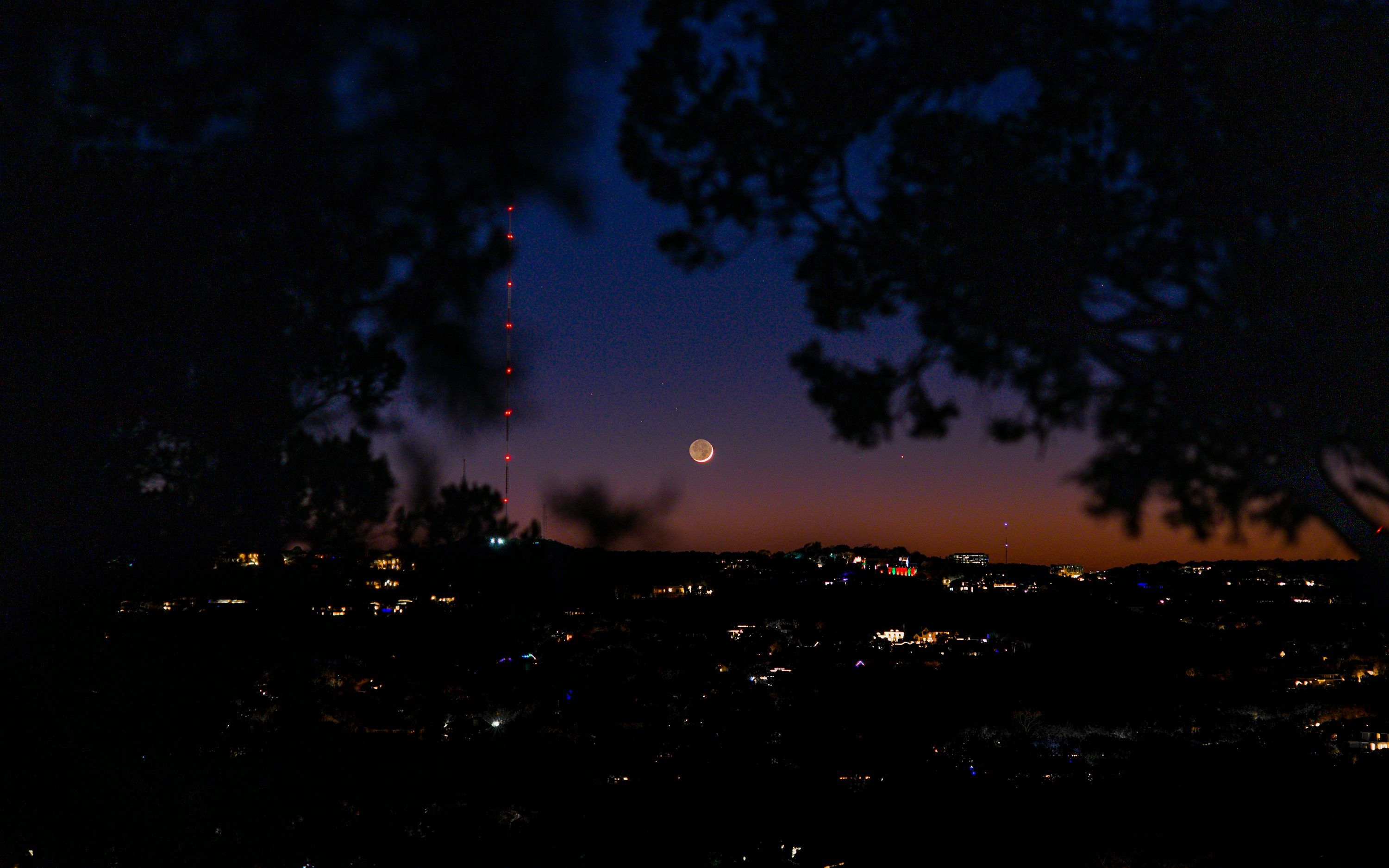 3000x1875 A view of a city from a hill at night photo