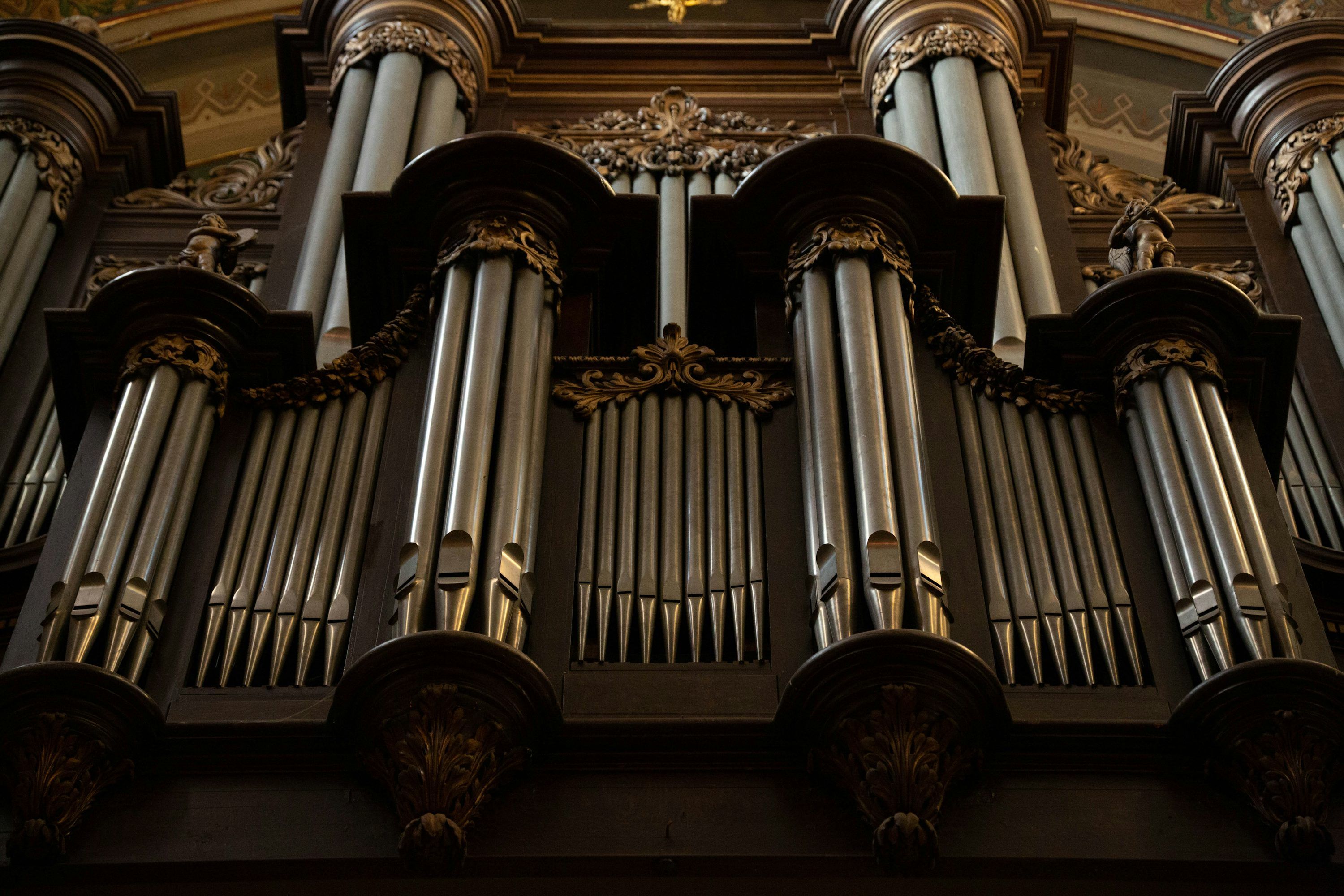 3000x2000 A large pipe organ in a church with a cross above it photo