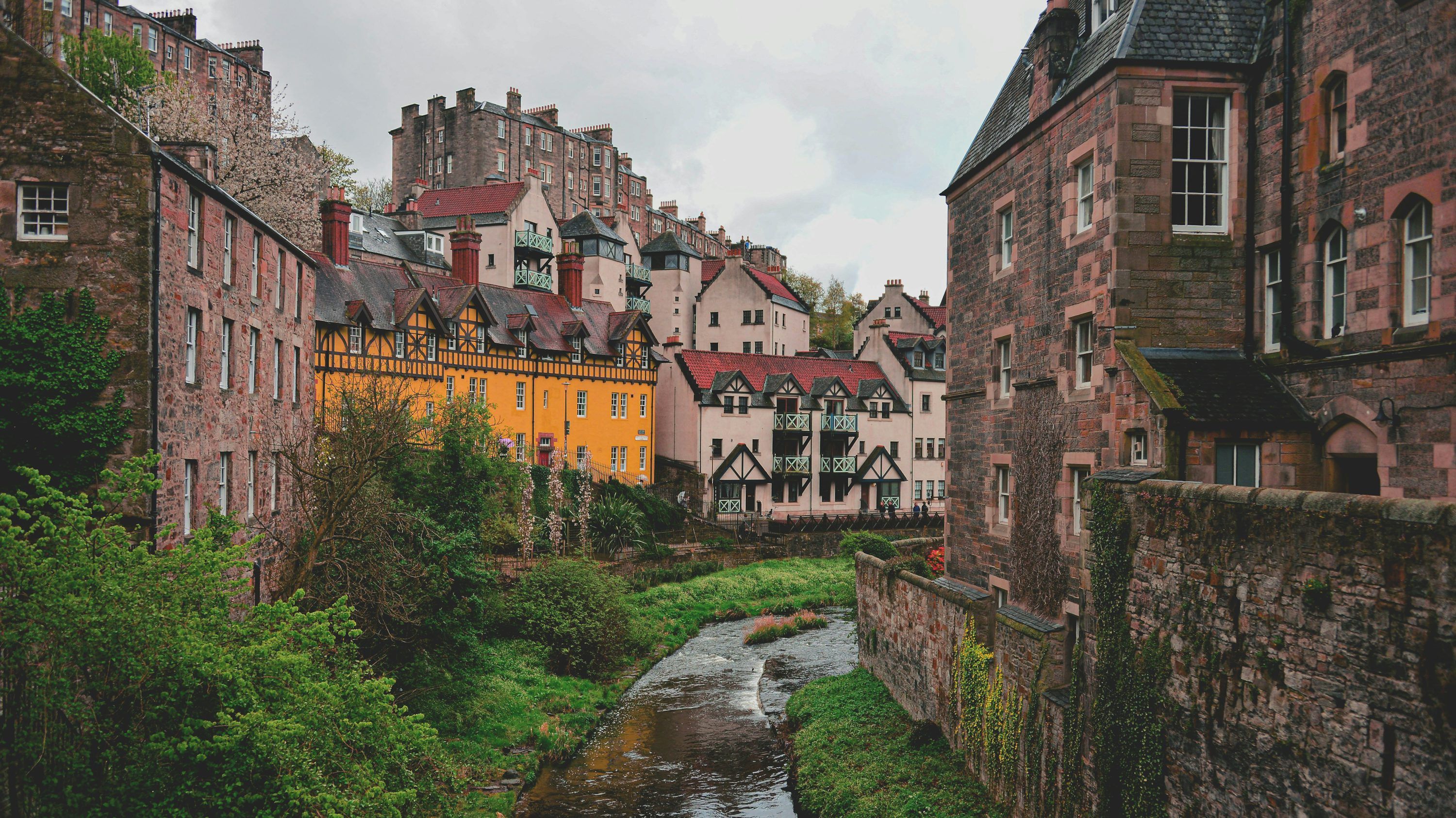 3000x1687 Historic buildings line a stream in a european city. photo