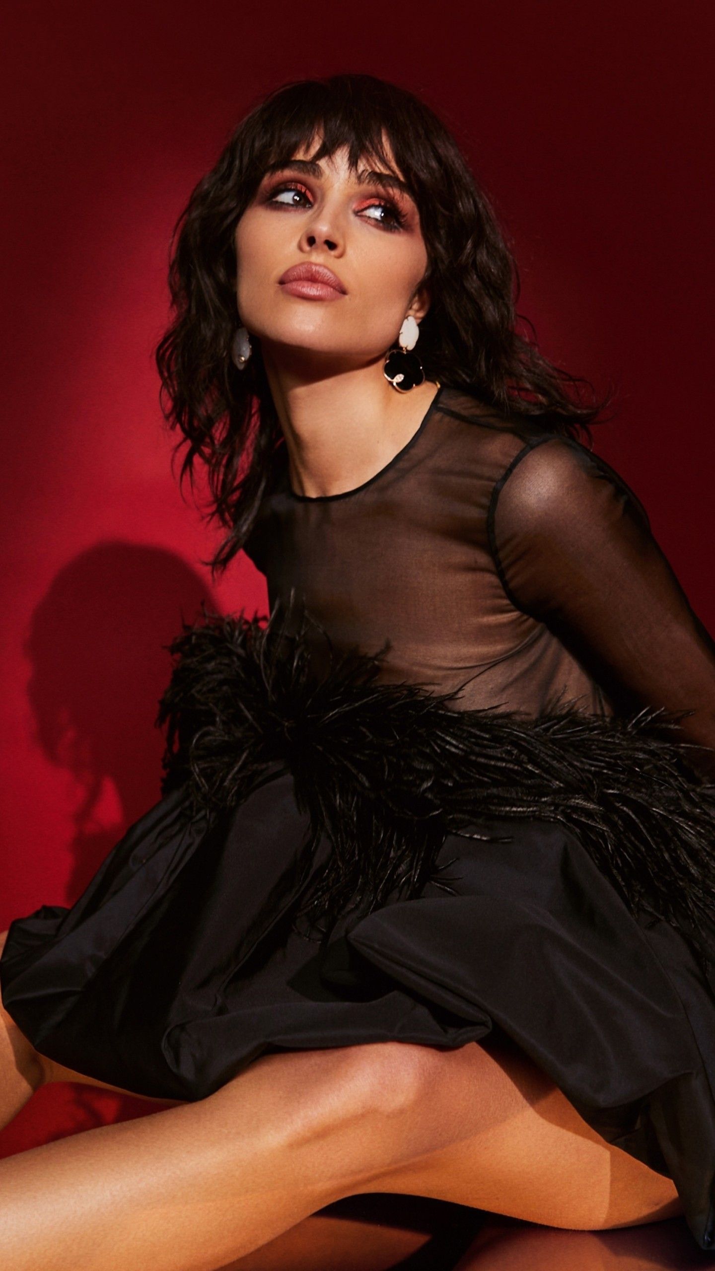 1440x2560 Girl Model Olivia Culpo Is Sitting On Floor Wearing Black Dress In Red Wall Background 4K HD Girls Wallpaper