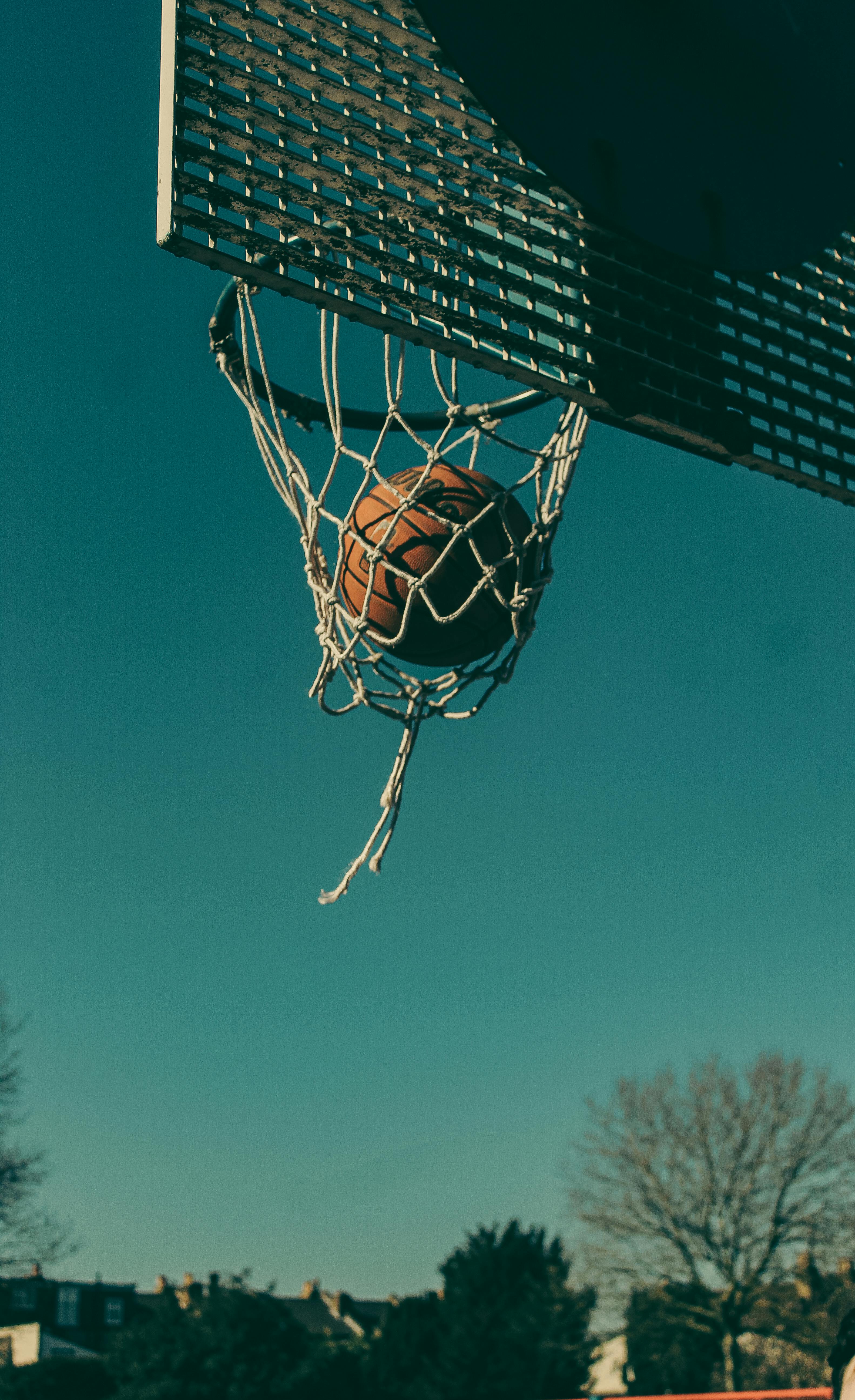 3165x5184 Close Up Of A Ball In A Basketball Hoop · Free