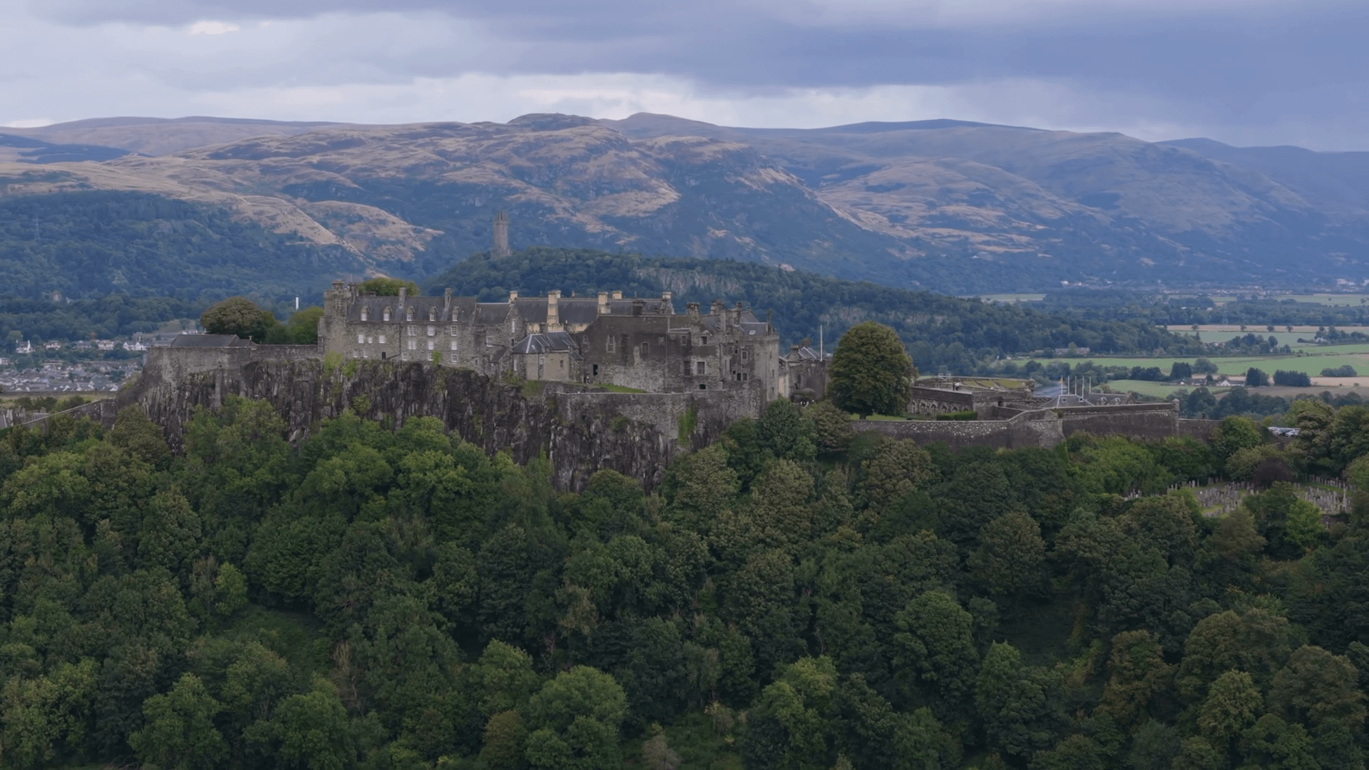 1920x1080 Aerial view of Stirling Castle in Stirling, city in central Scotland. Mountains in background on cloudy day