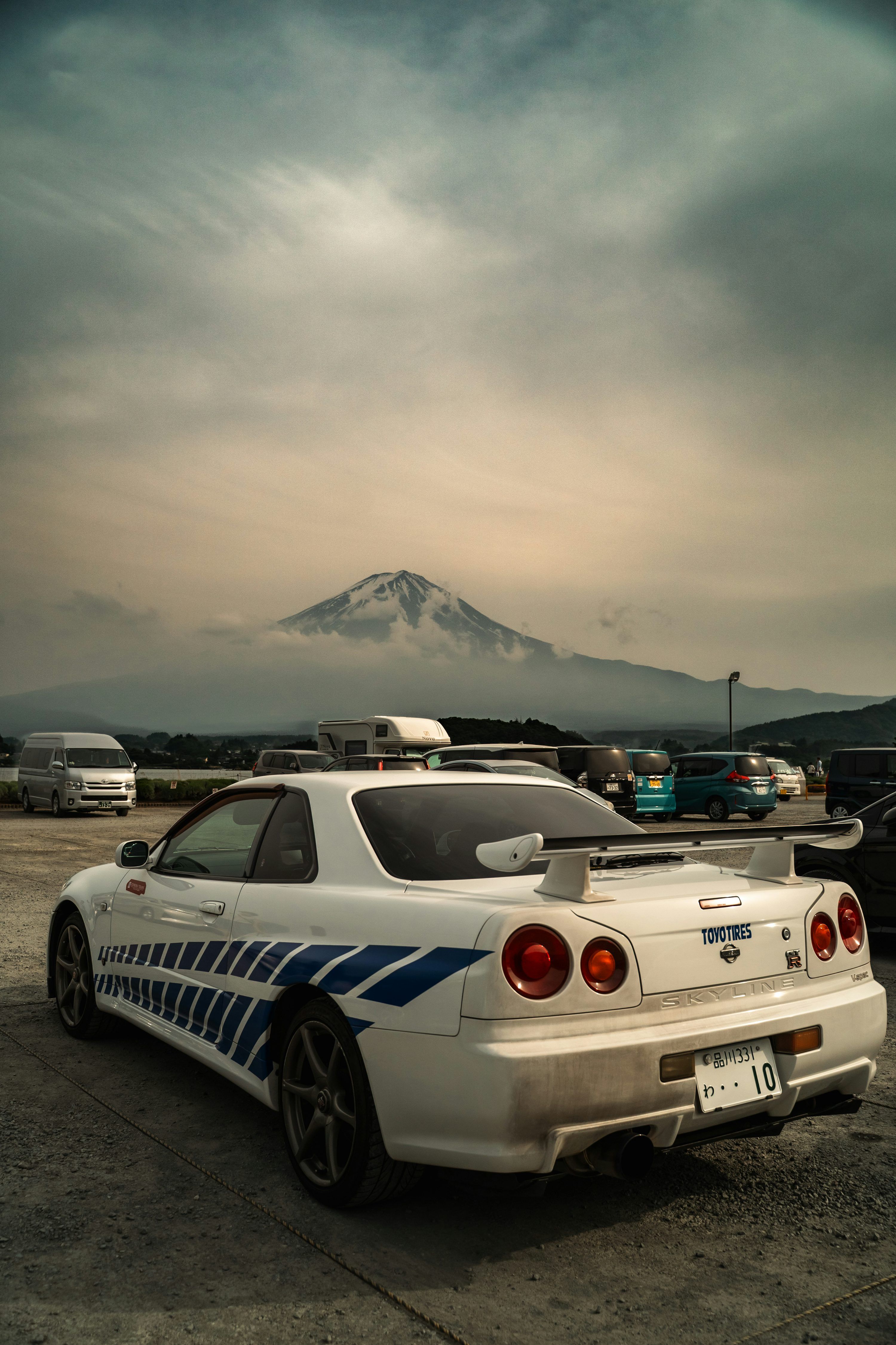3000x4500 Nissan skyline r34 parked before mountain. photo