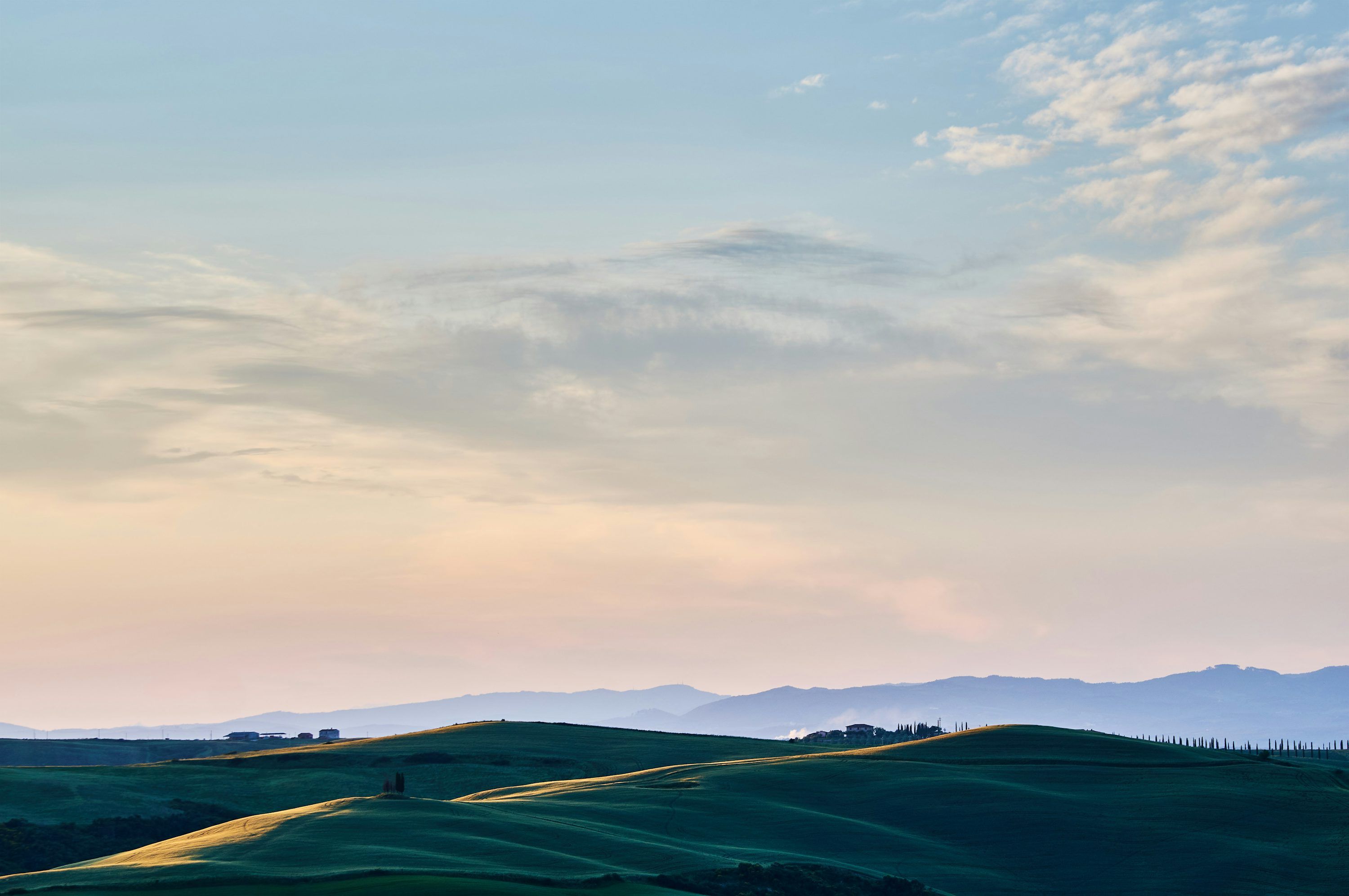 3000x1993 A view of a grassy hill with mountains in the background photo