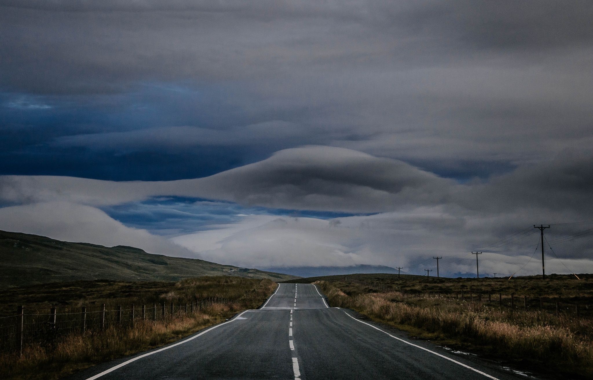 2048x1313 Wallpaper road, field, hills, fence, countryside, cloudy, power line, rainy for mobile and desktop, section пейзажи, resolution 2048x1313