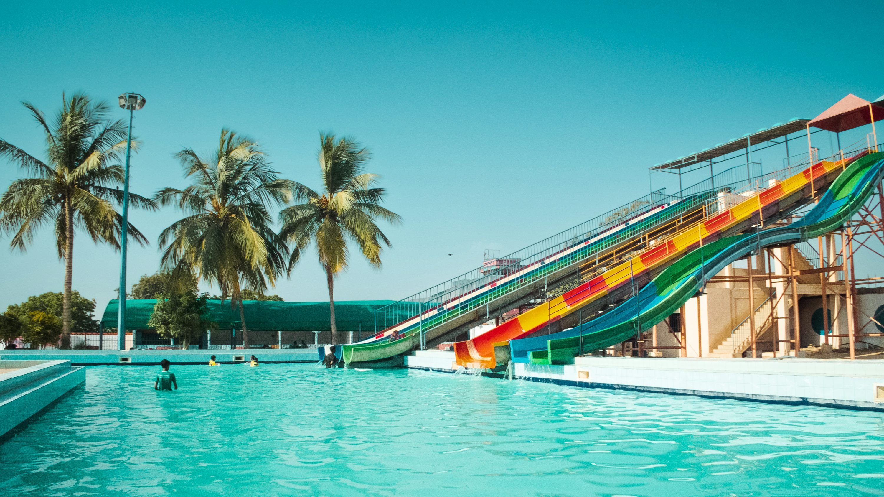 3000x1686 A water slide in the middle of a swimming pool photo
