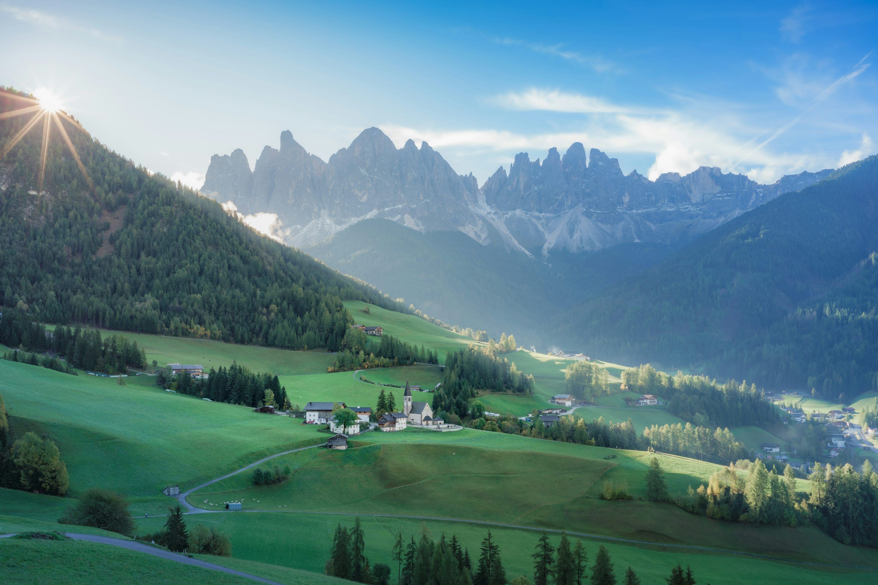 3000x2001 A scenic view of a valley with mountains in the background photo