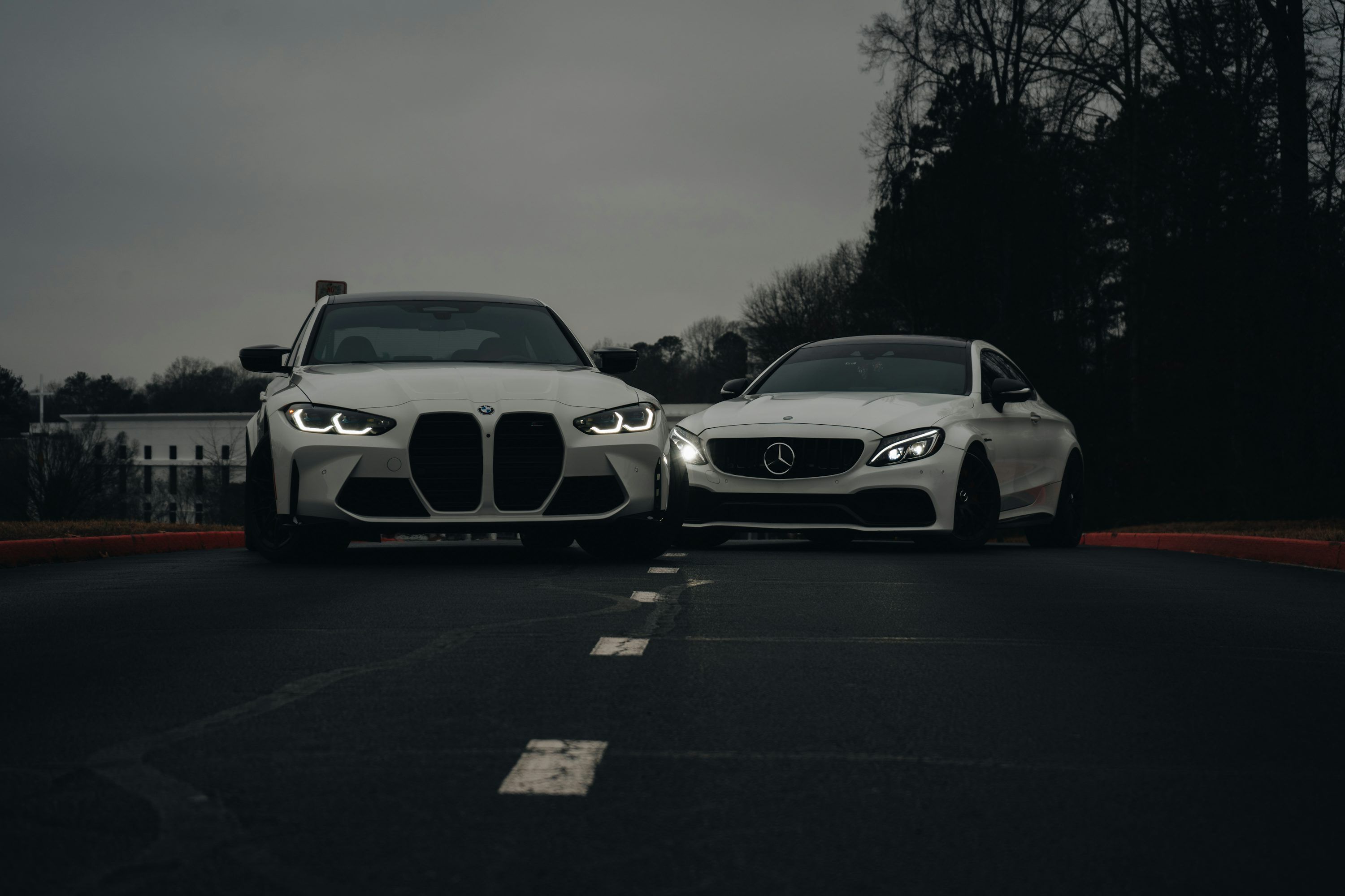 3000x2000 Two white cars parked on the side of a road photo