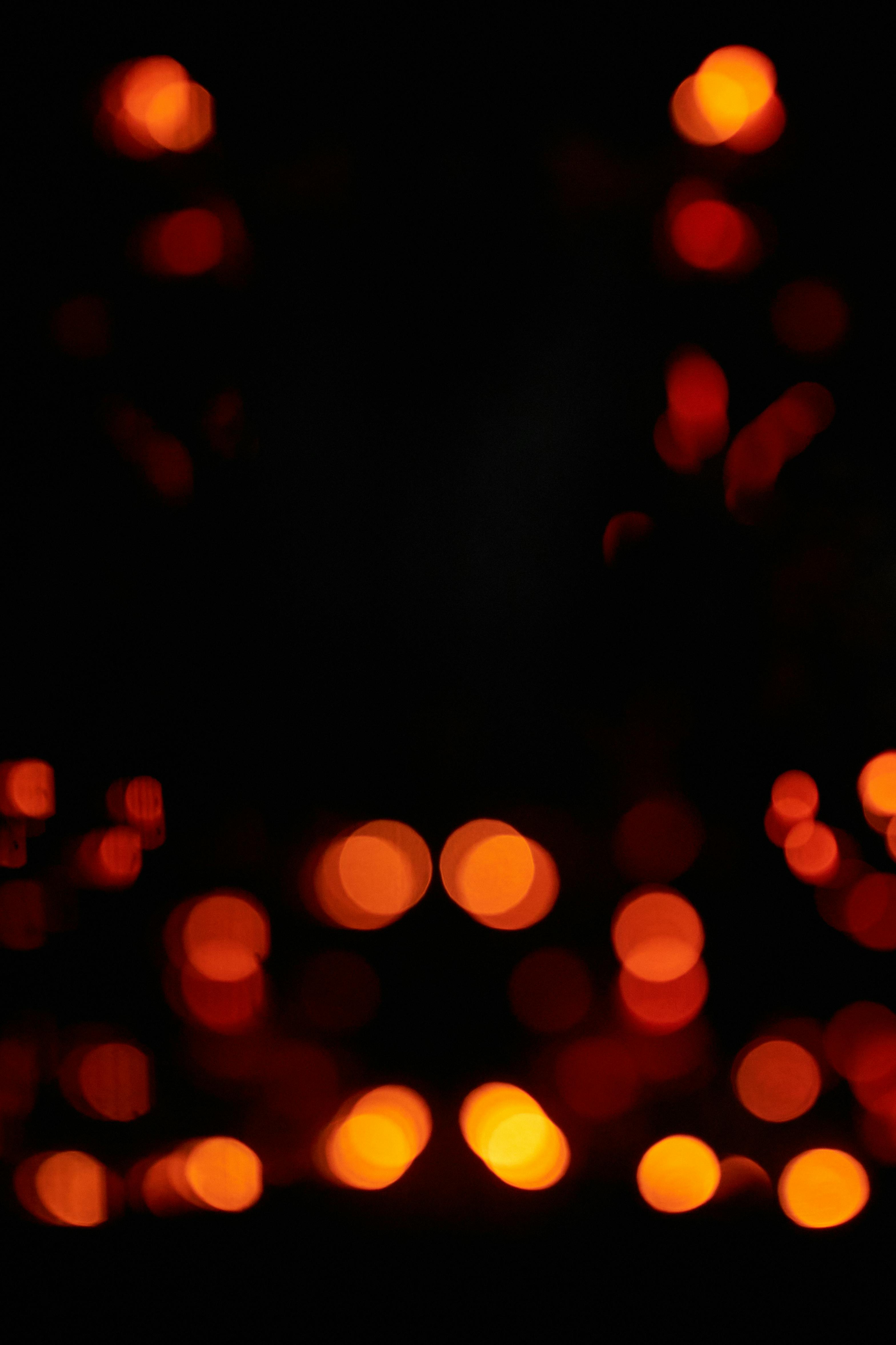 3137x4706 Unfocused blur orange light dots on black background · Free