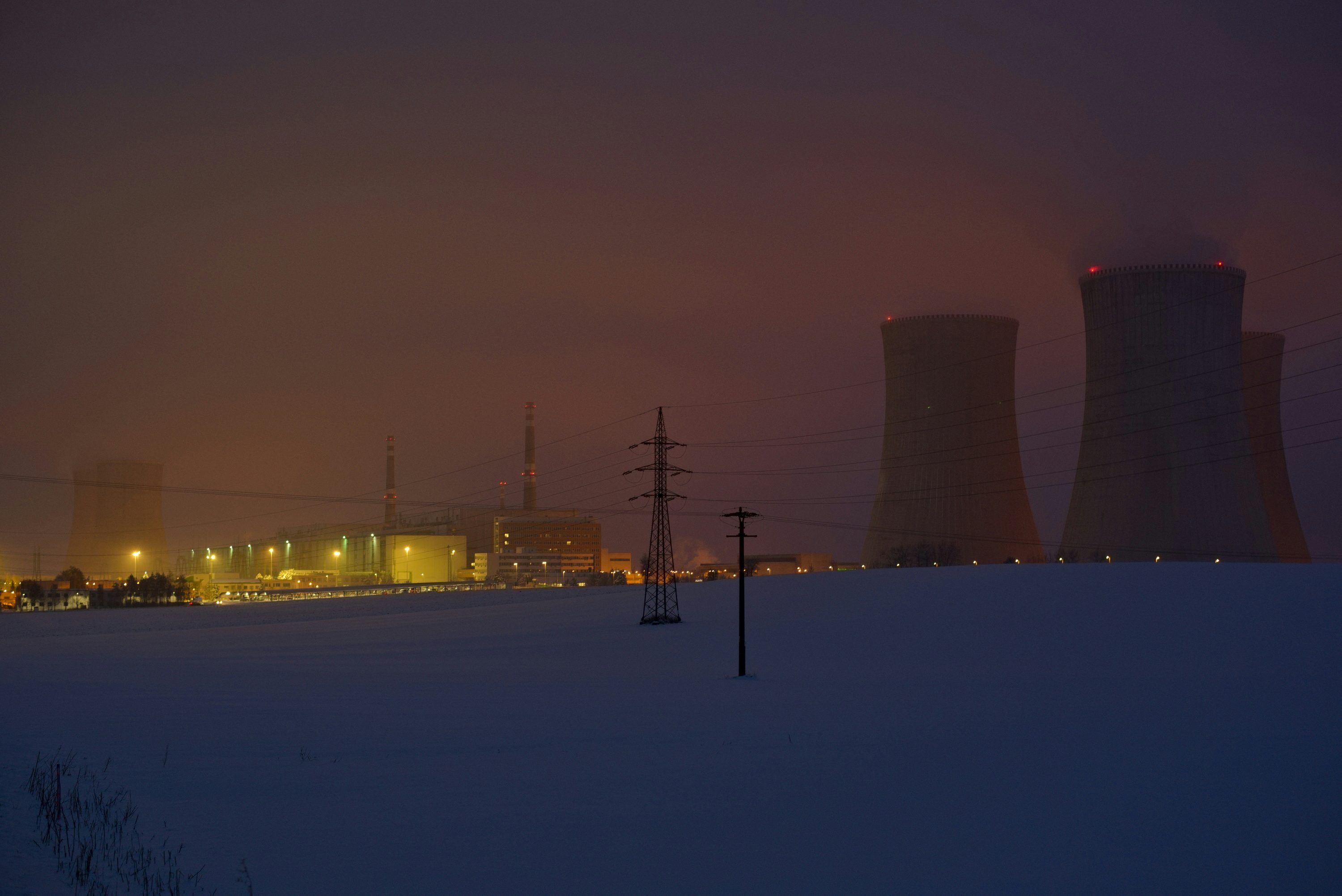 3000x2004 A snowy field with power lines and power plant in the background photo